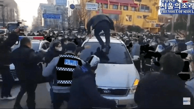 憤怒的民眾跳上車,肉身砸車表達抗議。(翻攝自서울의 소리 The Voice of Seoul YouTube頻道)