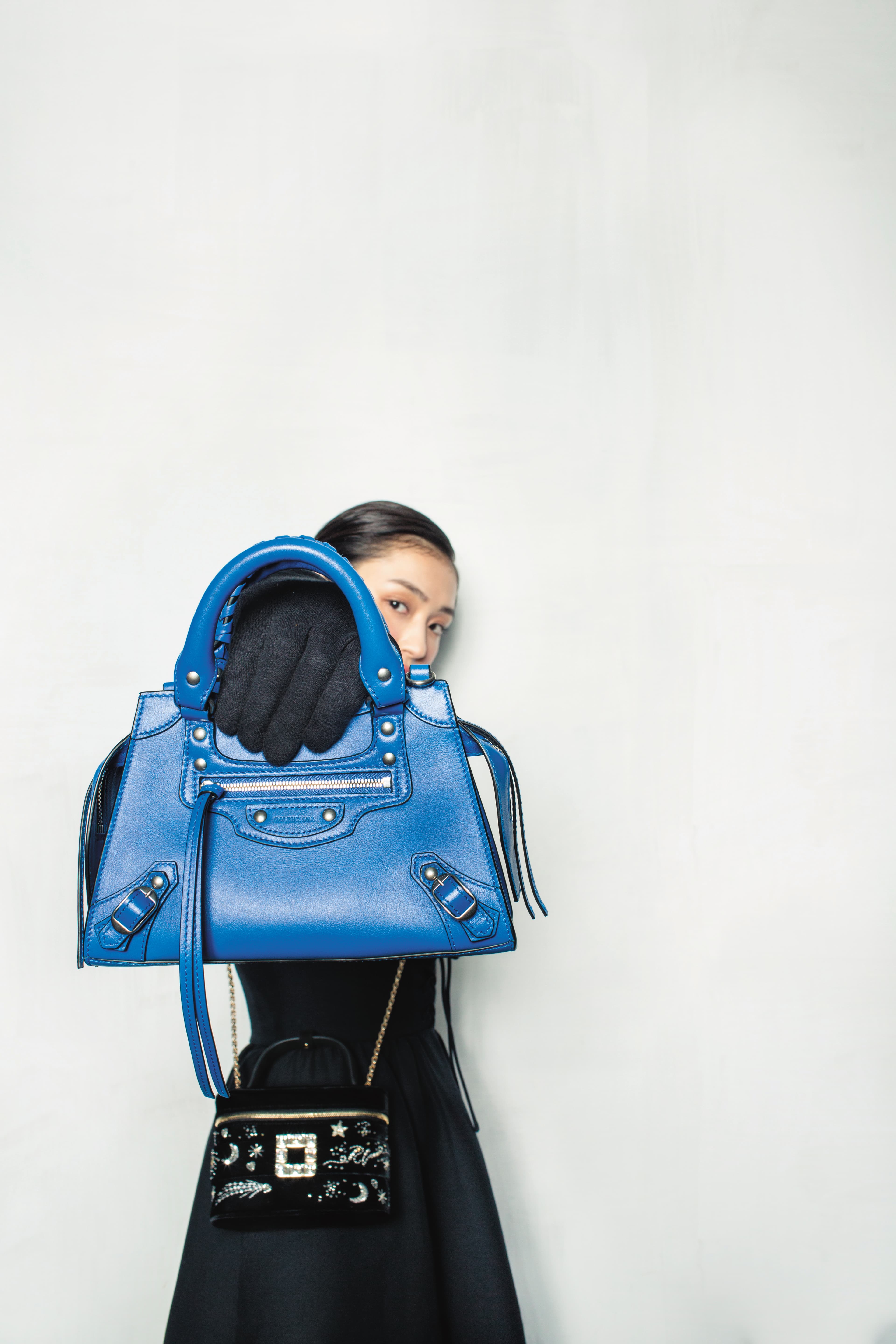 (前)Neo Classic City Mini迷你天藍色新機車包手提包NT$62,900 by BALENCIAGA;(後)Vanity星空刺繡鑽扣迷你提包NT$68,000 by Roger Vivier; 黑色羊毛高腰長裙NT$100,000 by Dior。