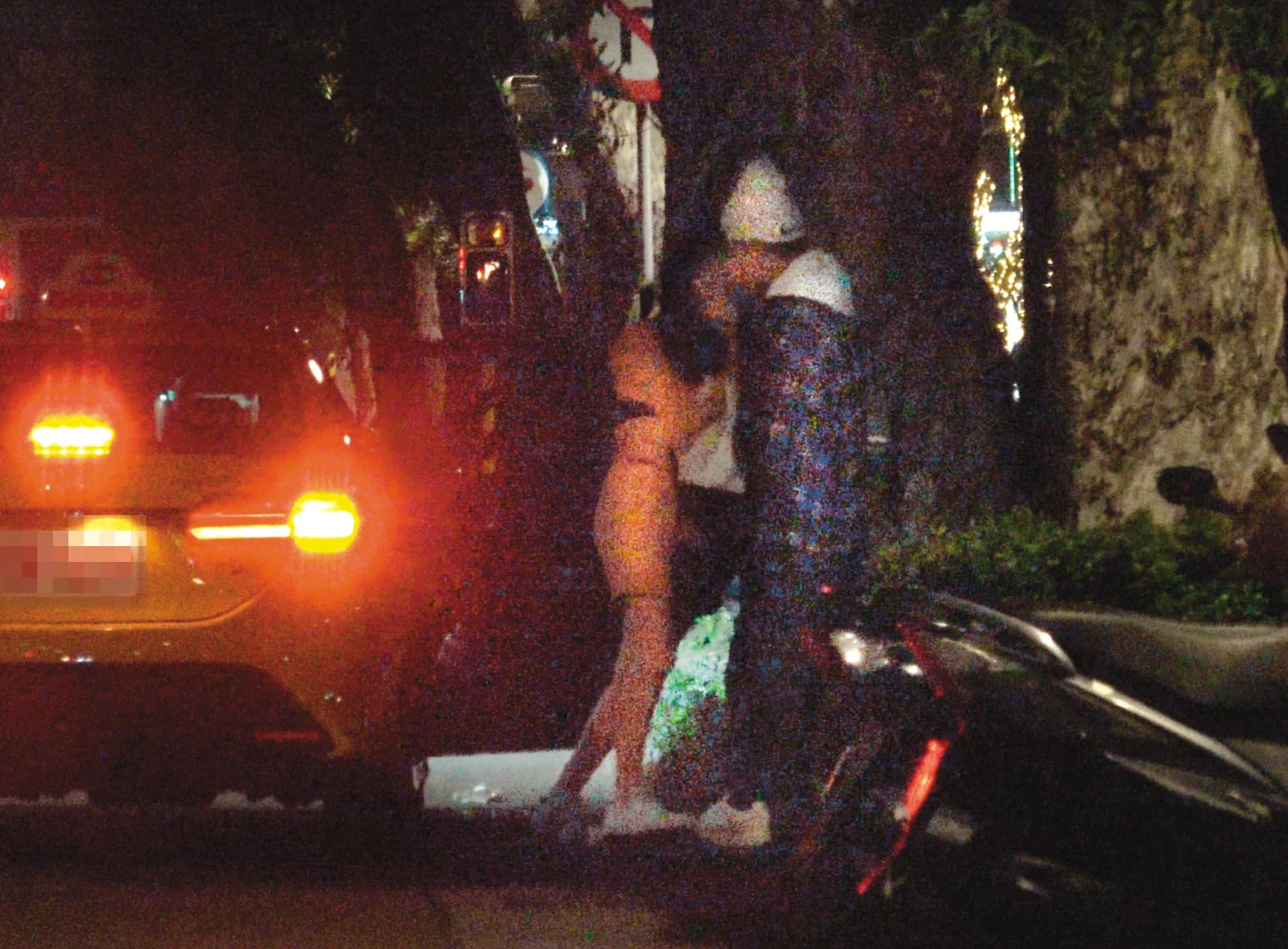 12/25,01:56,橘衣女子一下車,整個飛撲黏著周興哲,看來非常火熱,而且互動相當親暱。