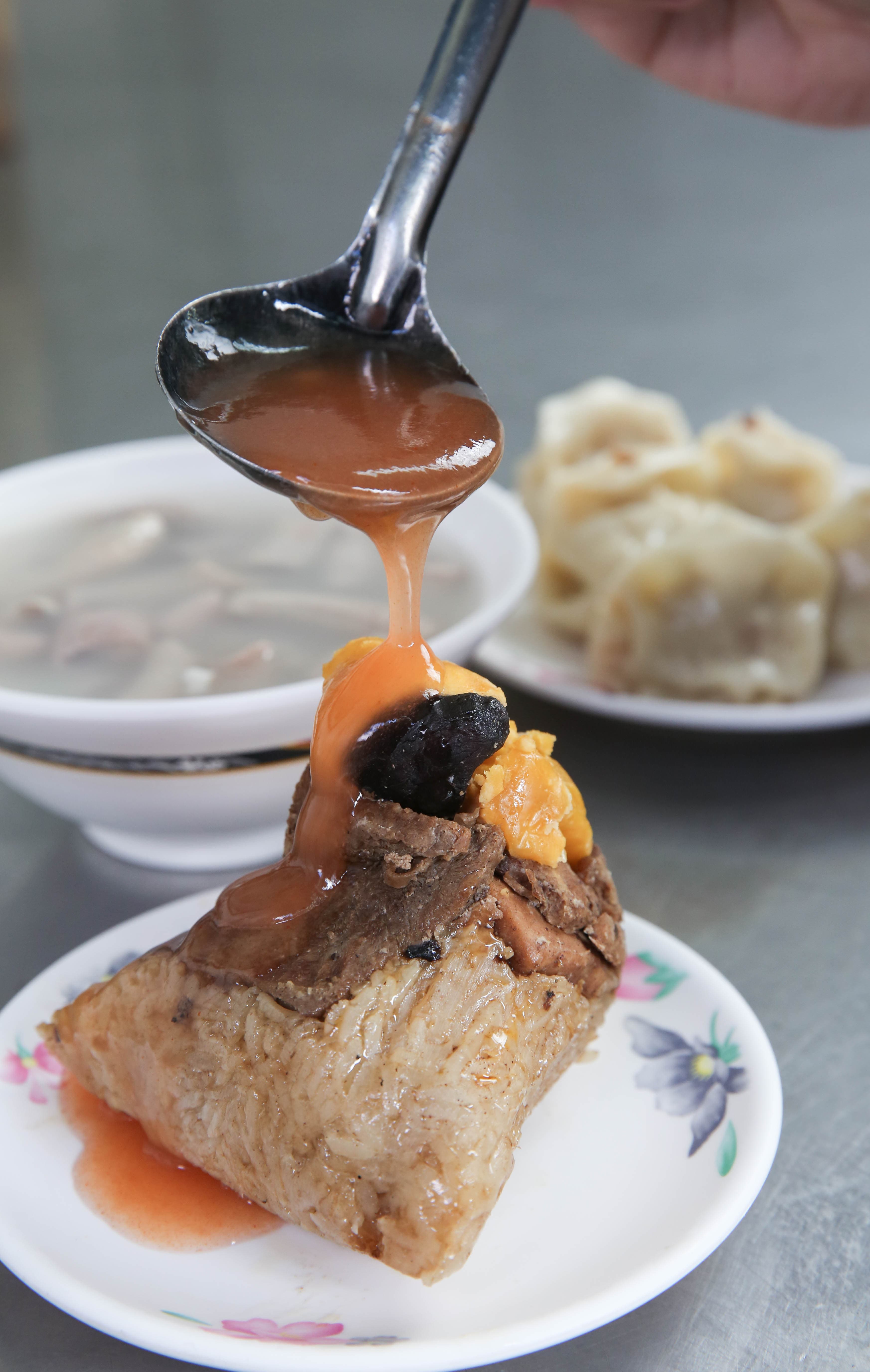 店內販售的北部粽,包入大塊豬肉與蛋黃,搭配自家熬煮的醬汁很對味。(50元/顆)