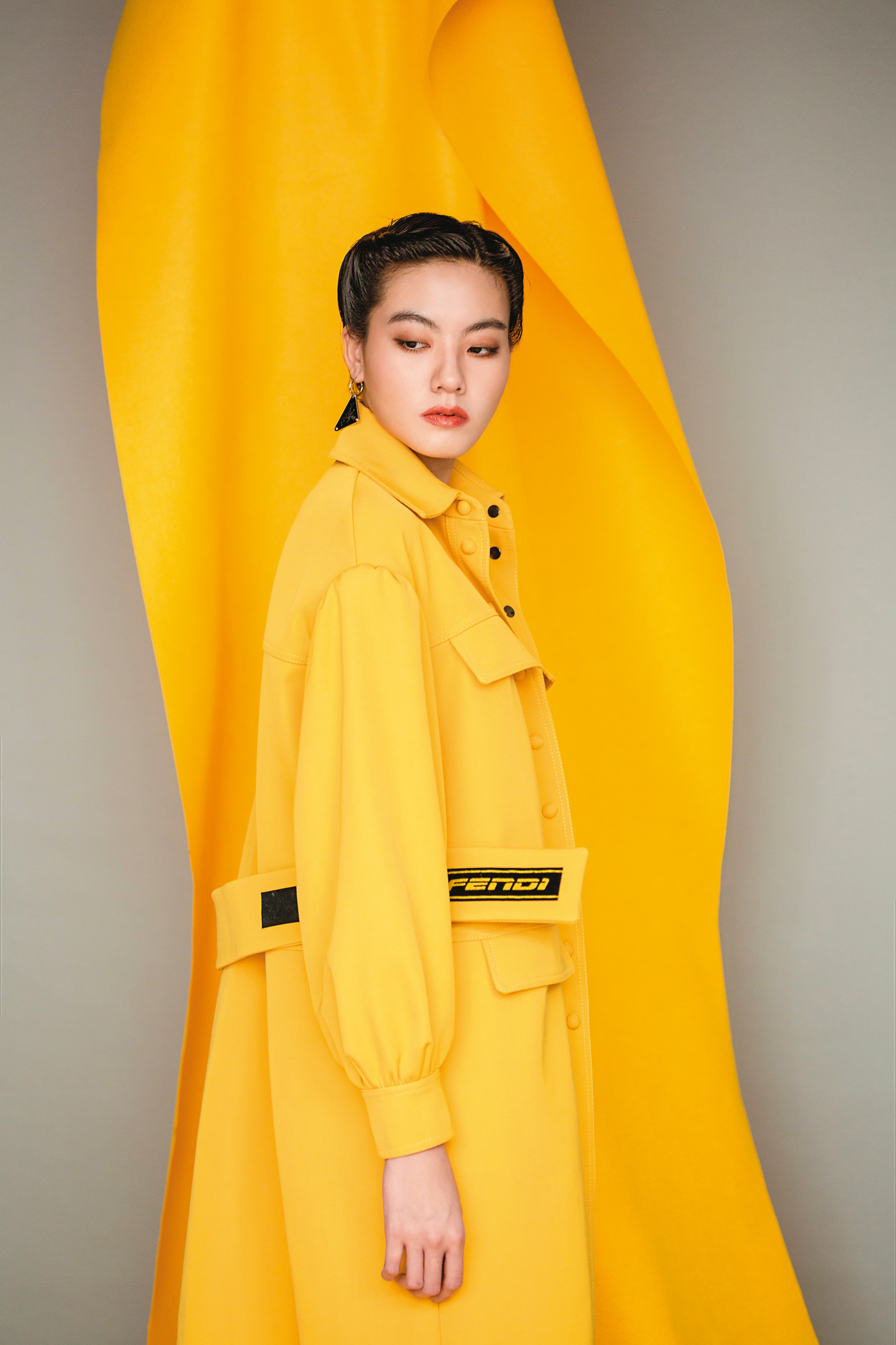 連身大衣 NT$122,000 by FENDI／三角標誌垂墜式單支耳環 NT$14,000 by PRADA