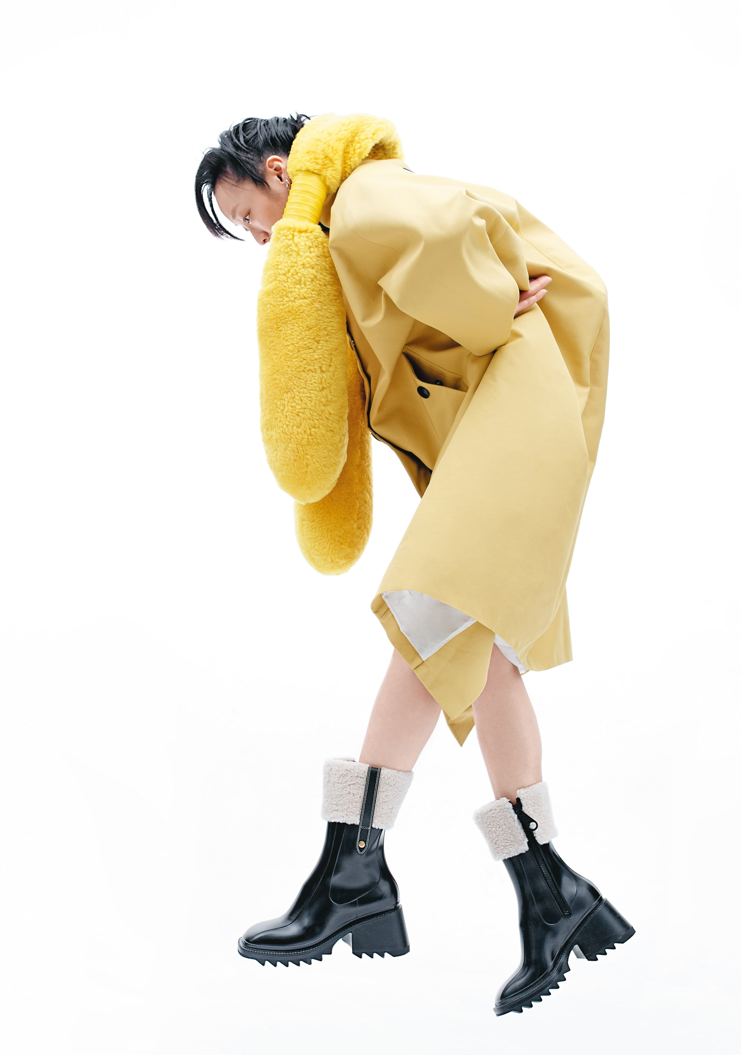 黃色防水風衣 NT$115,000 by PRADA/黃色翻羊毛長脖圍巾 NT$50,100 by BOTTEGA VENETA/Betty黑色羔羊毛飾邊雨靴 NT$19,800 by CHLOÉ