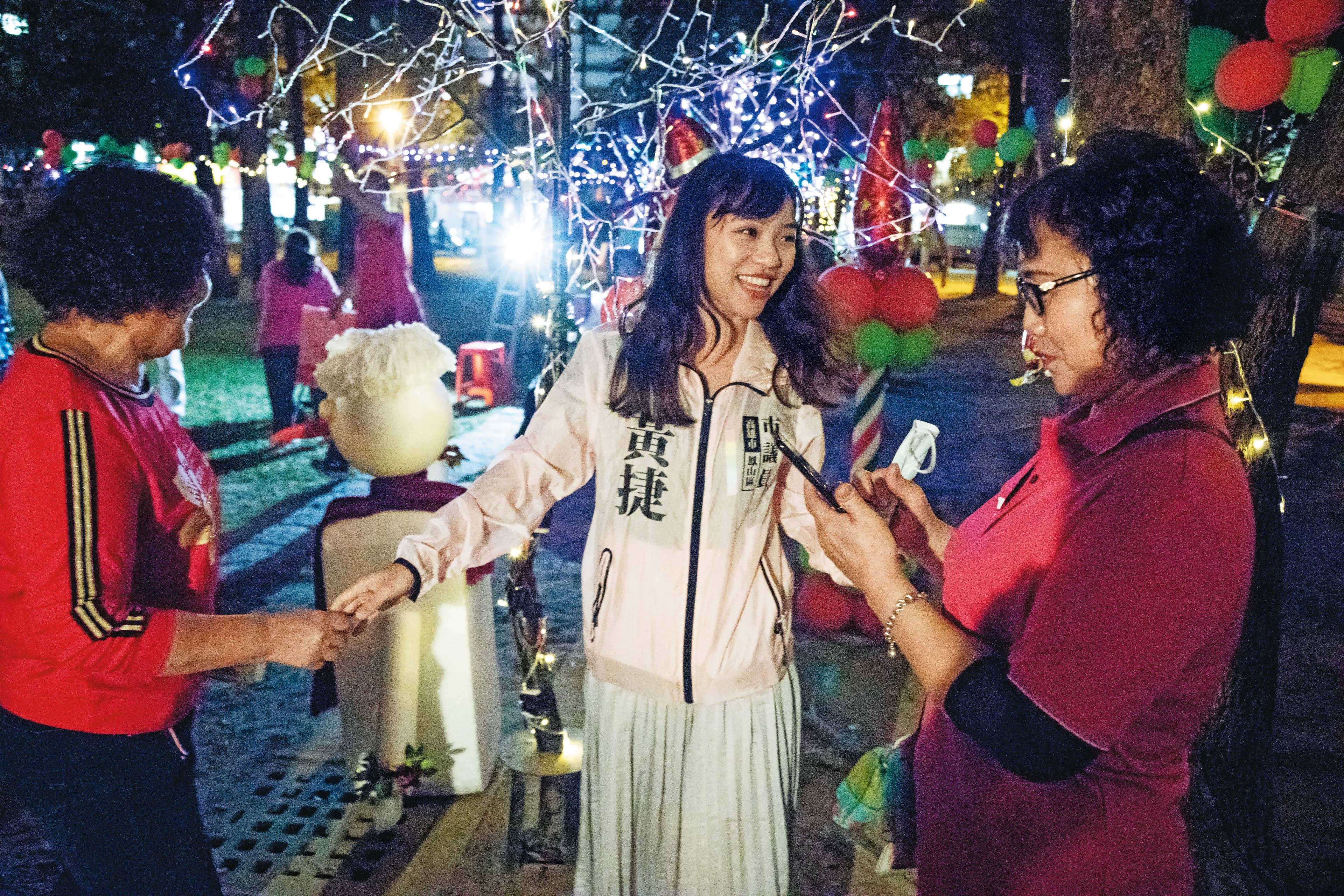 黃捷(中)在里民活動熱情與民眾寒暄,但還是顯得生澀,經常發出一連串哈哈哈的笑聲。