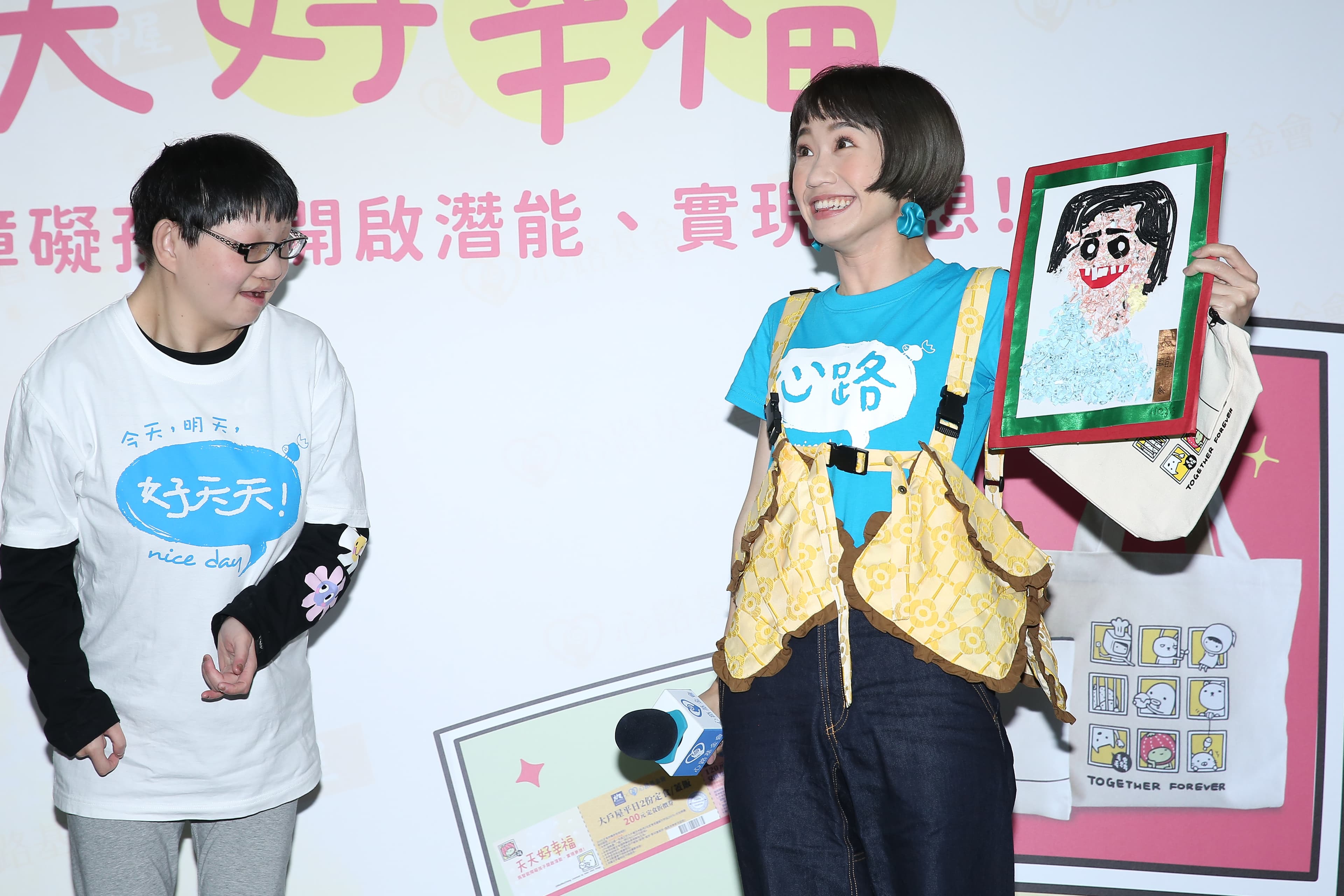 Lulu(右)二度成為心路基金會代言人,推銷義賣幸福提袋組,粉絲瑜宸(左)獻上親手繪製的畫像,真是讓人感動的摸們。(本刊資料照)