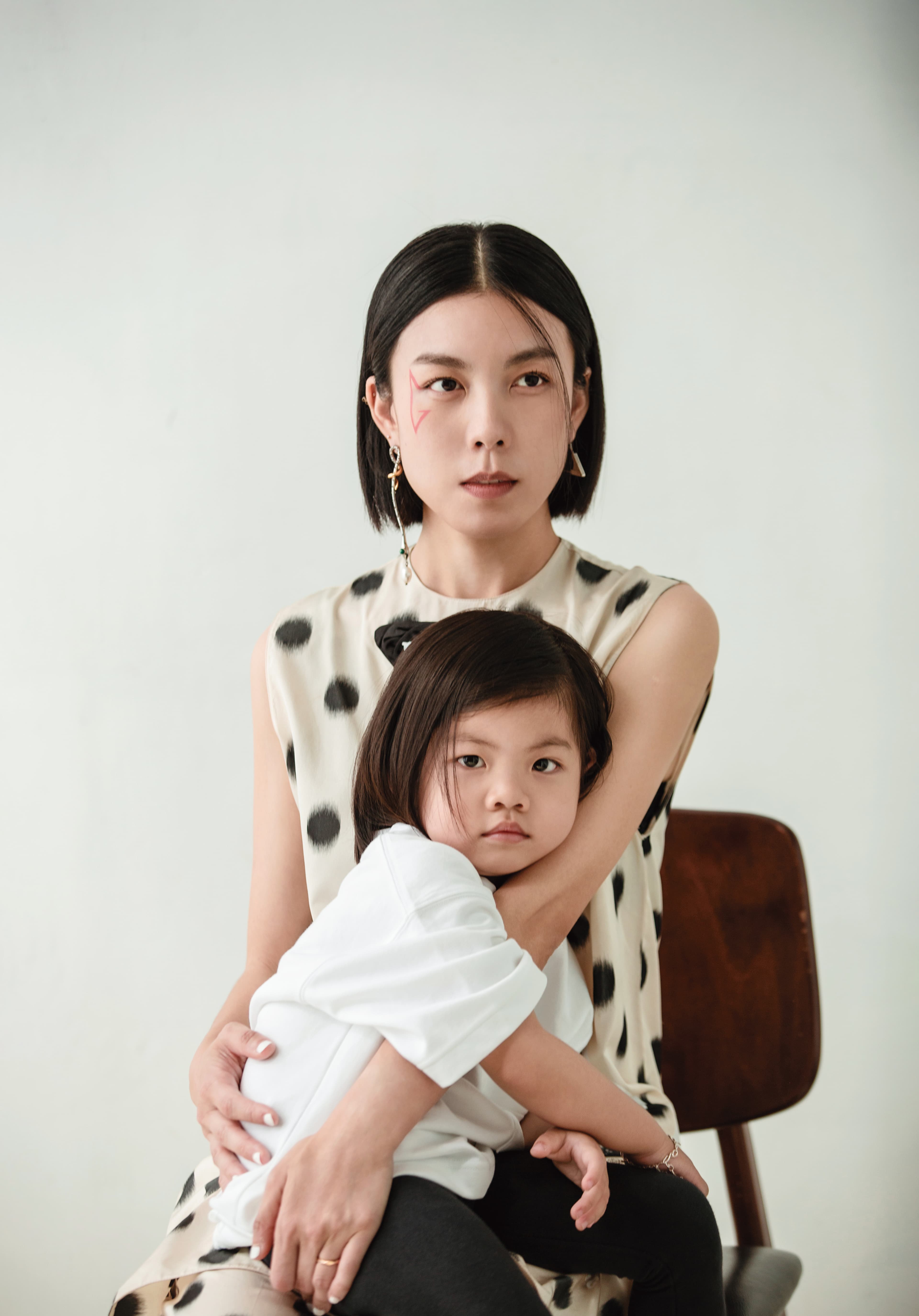 圓點無袖洋裝 NT$80,000 by PRADA／圓點直筒長褲 NT$84,000 by PRADA／（左）垂墜耳環 價格店洽 by Chloé／（右）三角Logo耳環 價格店洽 by PRADA