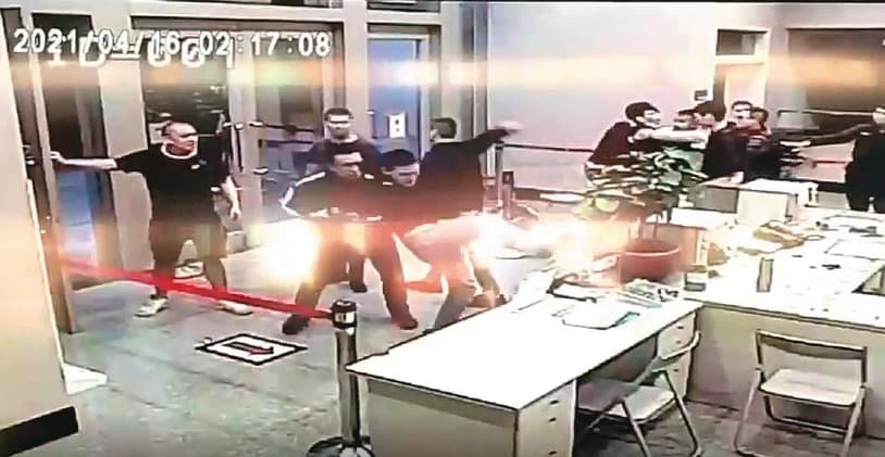 10名黑衣人在路上追打松山分局楊姓教官,並衝入派出所砸毀電腦。(翻攝畫面)