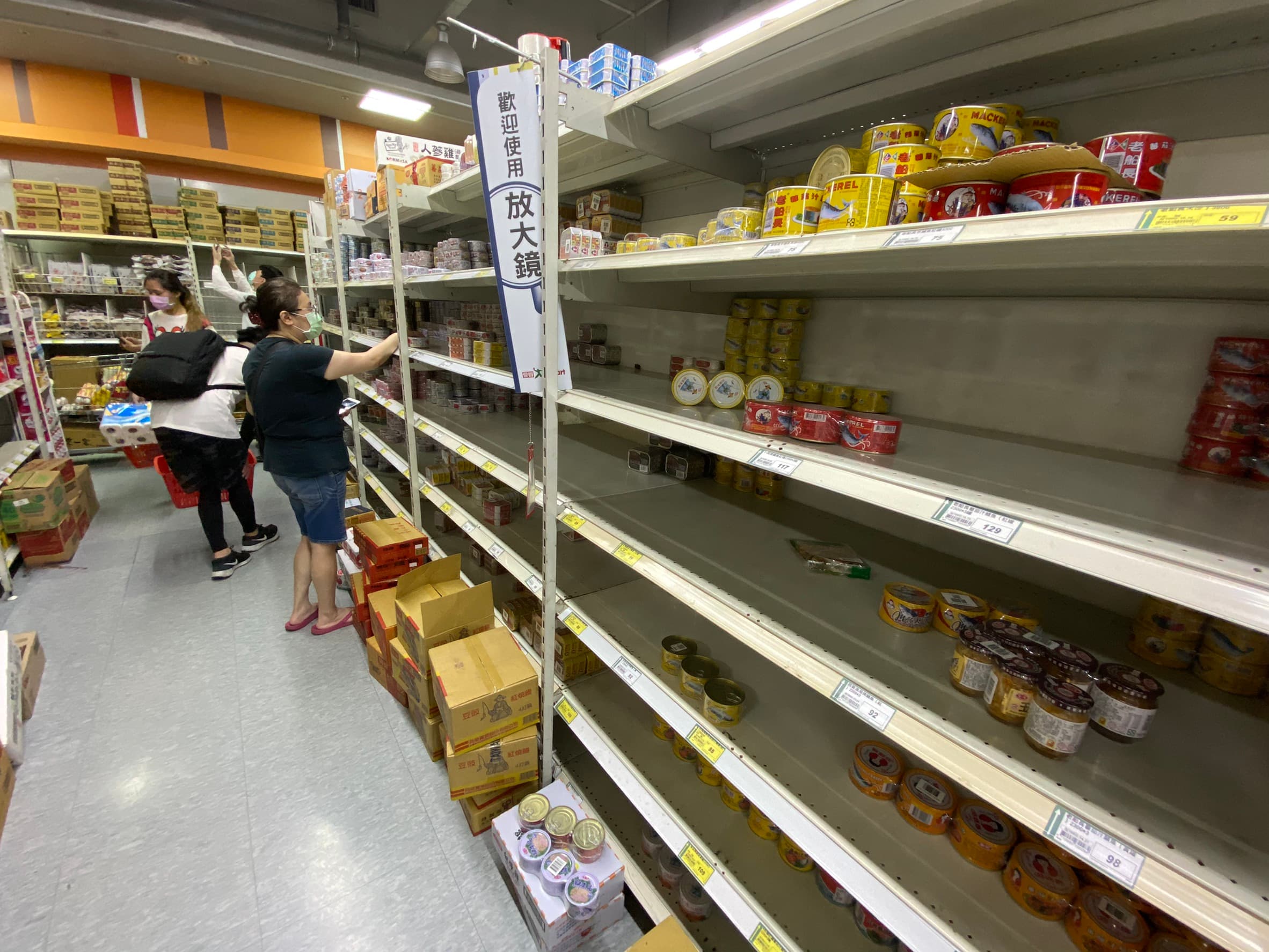 就連超市的架上，民眾也瘋搶罐頭，可以看到店員不斷補貨。