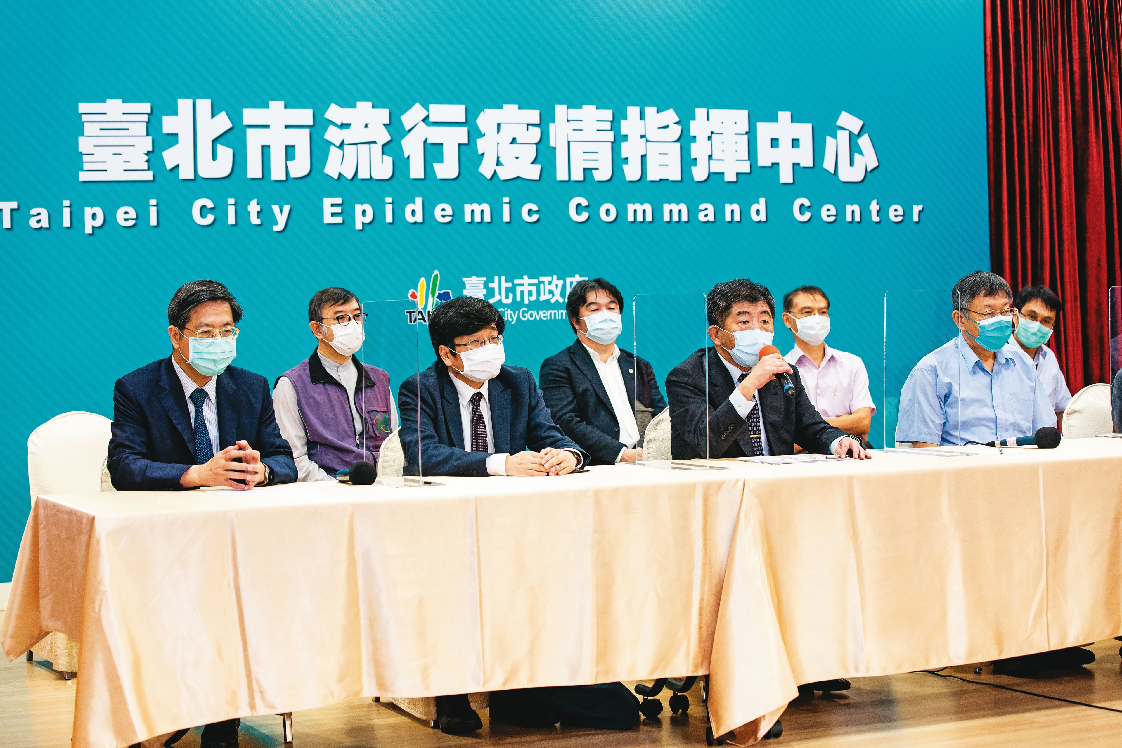 陳時中(前排右2)14日率指揮中心官員與台北市長柯文哲(前排右1)合體開記者會,聯手宣布北市率先在感染熱區設立快篩站。