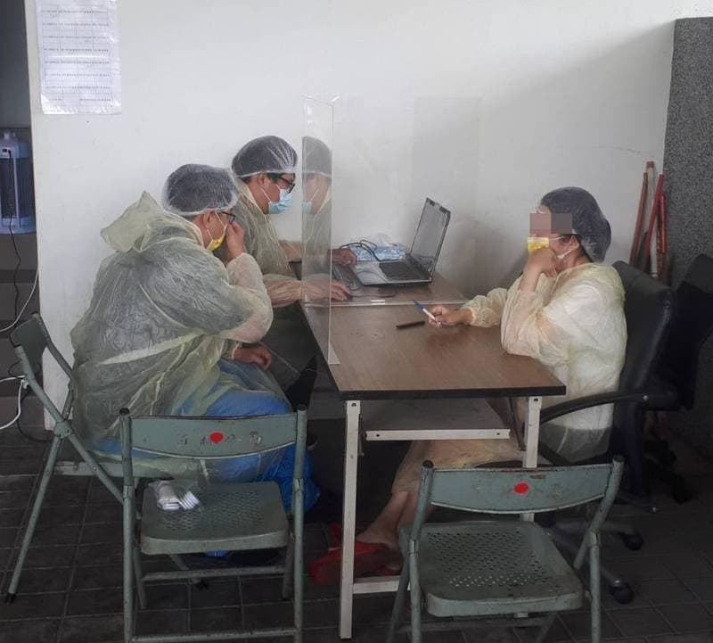 員警對詹女偵訊時全身著防護衣，詹女供稱，雖然害怕，但沒錢不得不接客。（讀者提供）
