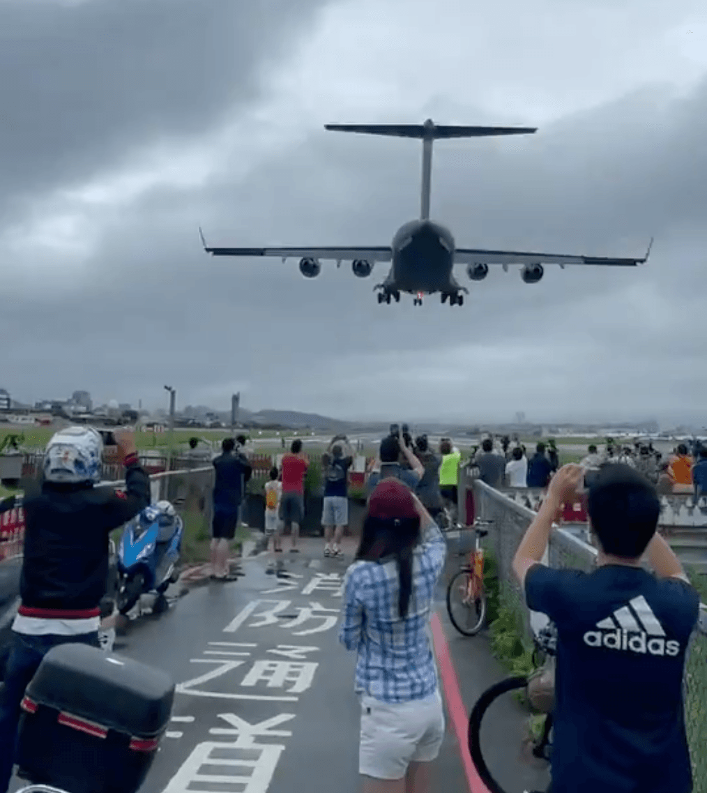 C-17從天而降,民眾肩並肩爭相搶拍,似乎沒有遵守社交距離。(翻攝poppy208209推特影片)