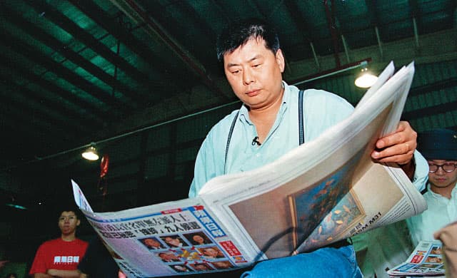 1995年6月20日《蘋果日報》創刊，當時47歲的黎智英正在閱讀創刊號。（翻攝自香港《蘋果日報》）