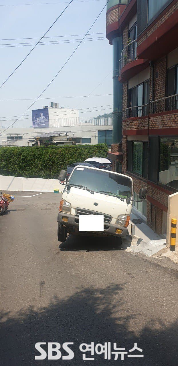 由於道路高度過陡,曾造成載貨卡車向後滑的事故,不過龍山廳道路交通科表示應為超載所致。(翻攝自SBS新聞)