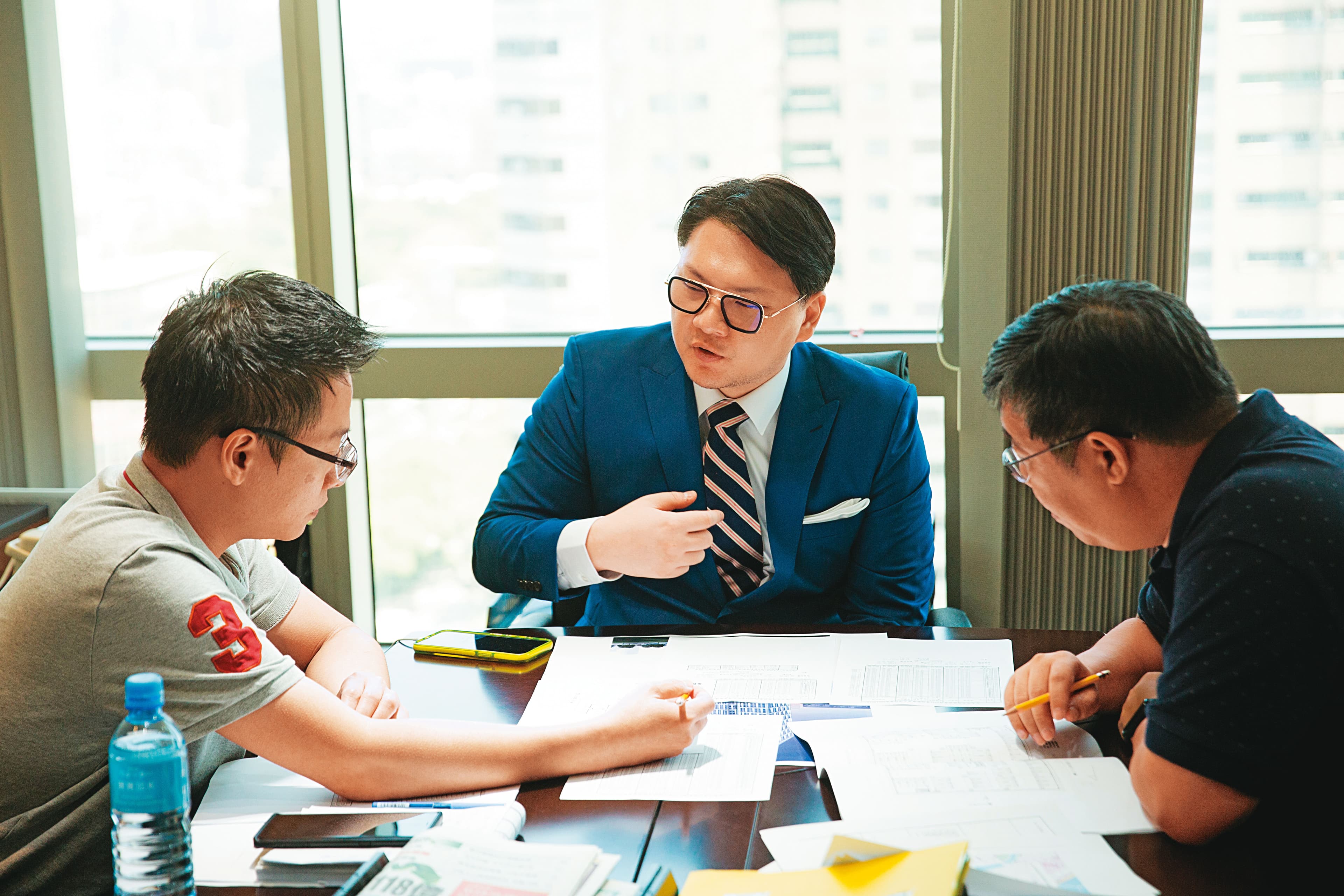 採訪當天,鍾育霖(中)正在商談旗下建案規劃,不到40歲的他已經是一家百億集團操盤人。