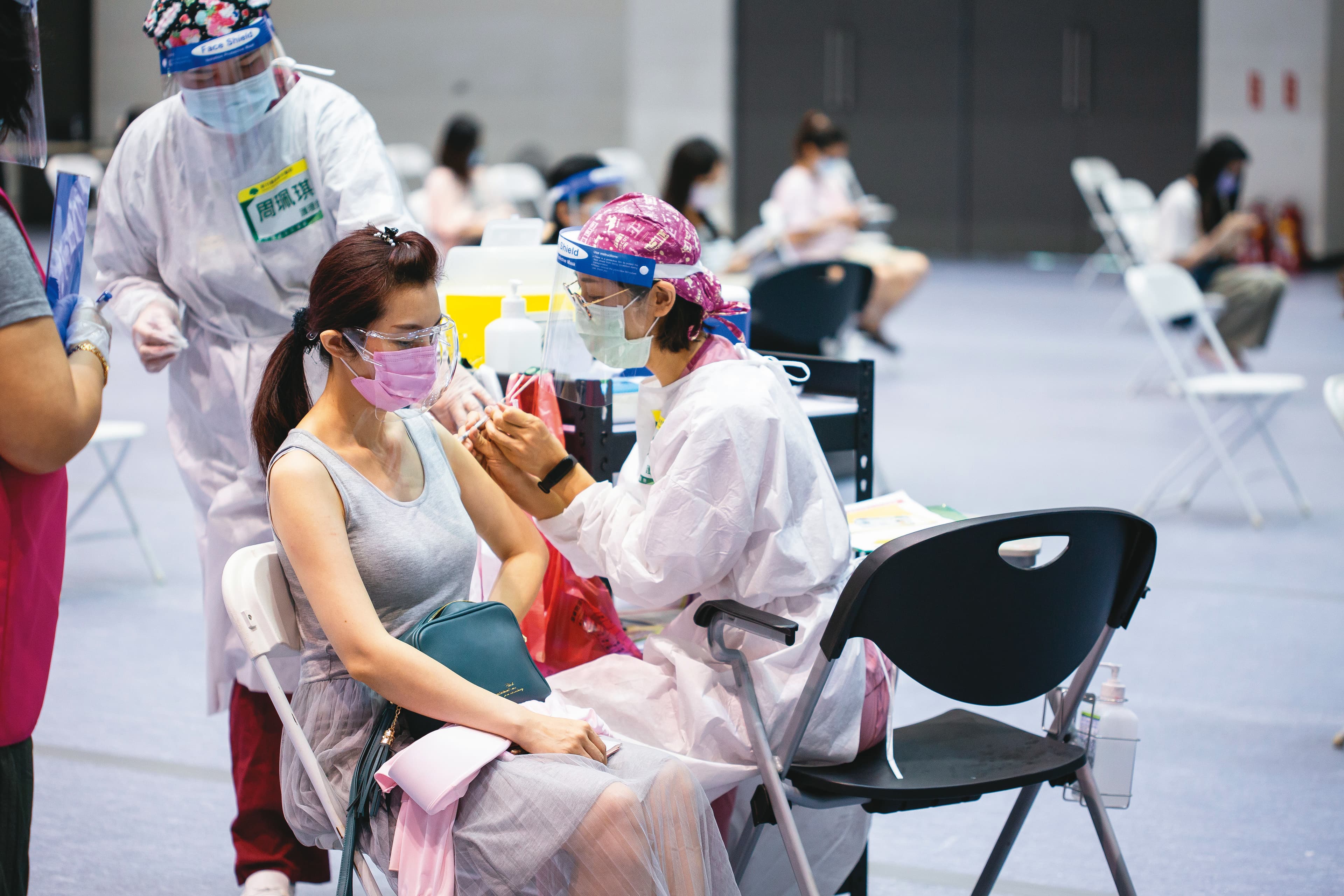 台大公衛學院模擬數據,若每天可接種疫苗15萬人,即便降至2.5級警戒,每天確診數仍可壓制在30人以下。圖為民眾施打疫苗畫面。