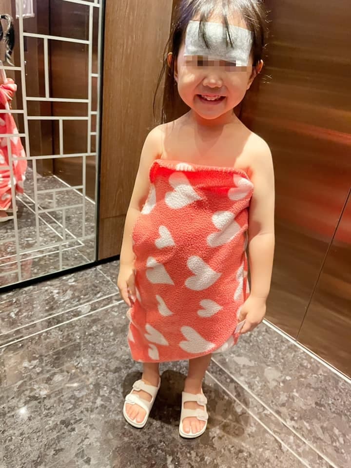 嚴立婷女兒發高燒在診所不小心吐了出來,只好跟診所借了小毛毯裹著身體。(翻攝自嚴立婷臉書)
