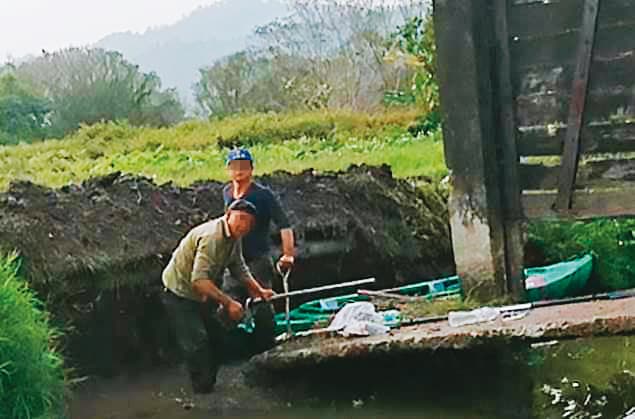 黃順昱疑似雇工偷挖堤岸,破壞古蹟水門和便橋,被村民逮個正著。(讀者提供)