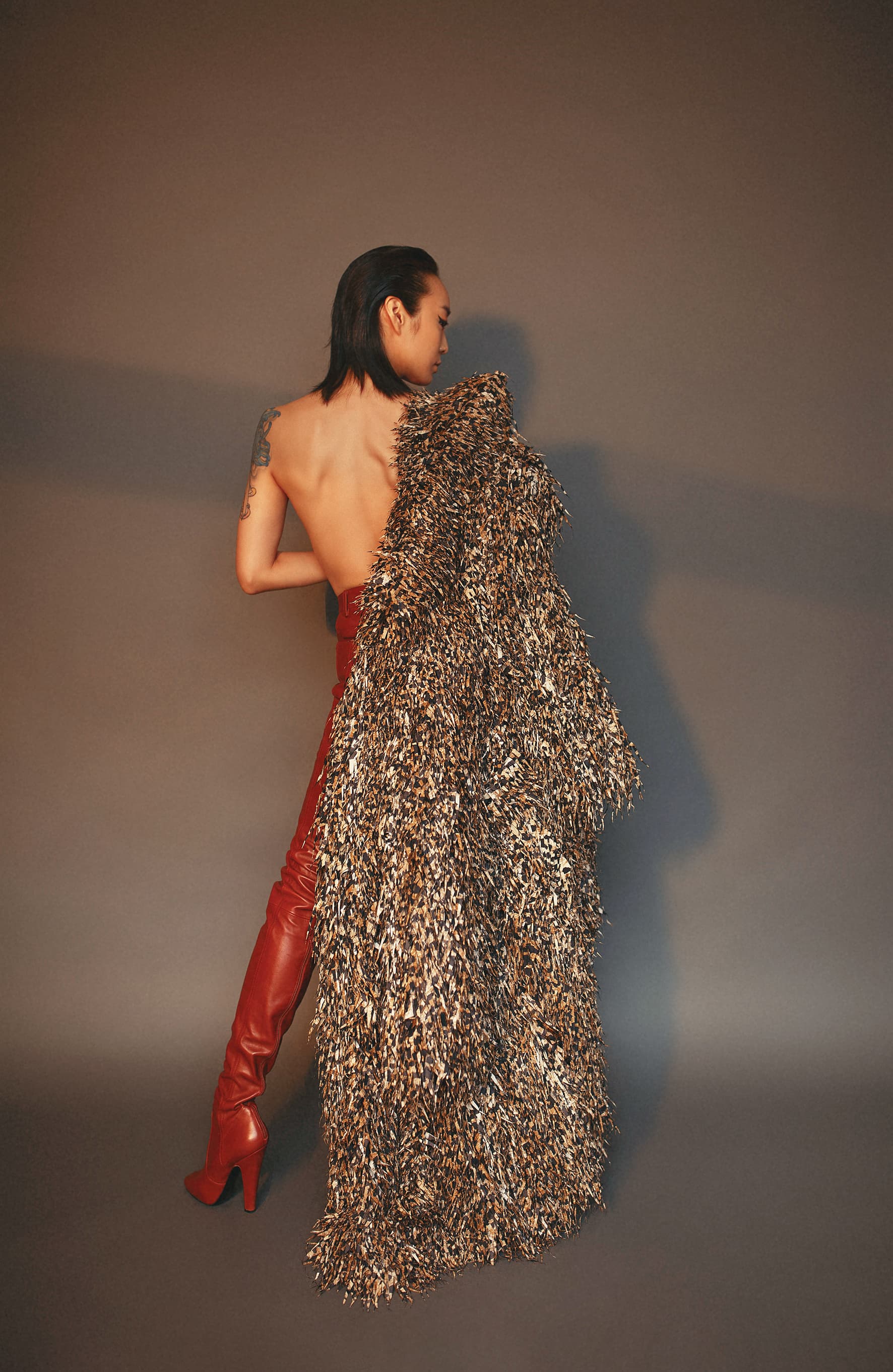 環保布料造型大衣 價格店洽 by BALENCIAGA；橘紅色皮褲靴  價格店洽 by SANIT LAURENT。