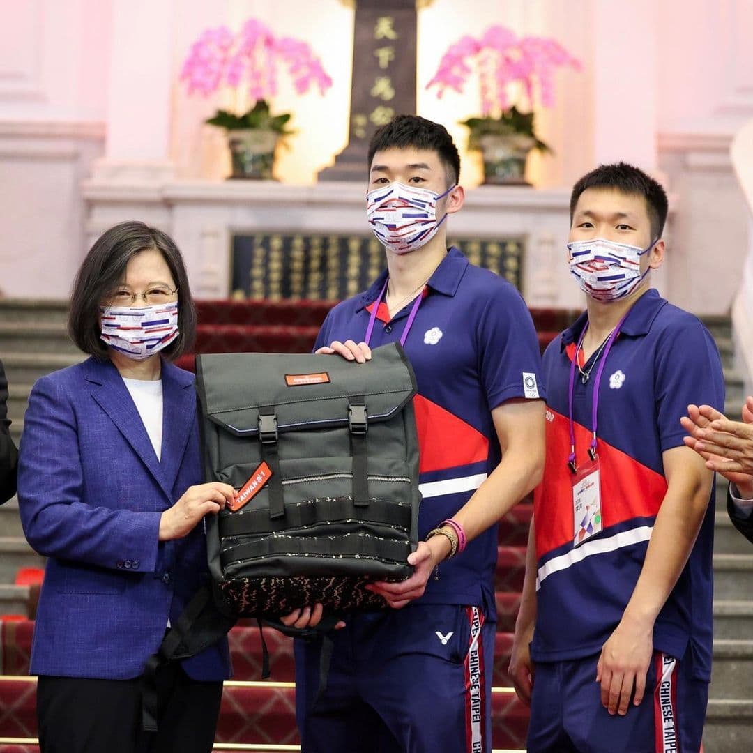 蔡英文送給選手有著「TAIWAN #1」的總統府特製背包,羽球選手王齊麟(中)、李洋(右)代表受贈。(翻攝tsai_ingwen IG)