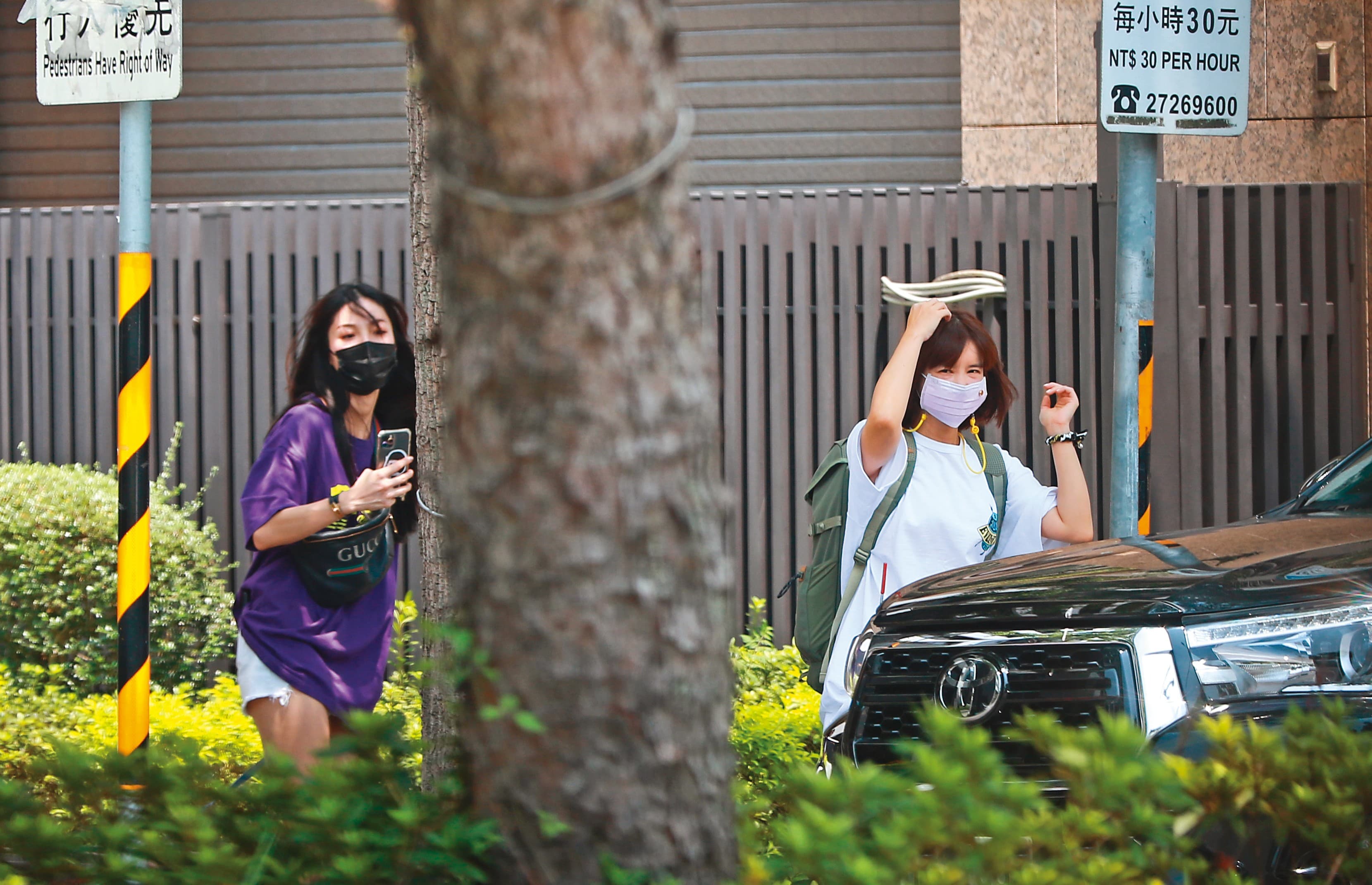 8月22日12：53， 李佳穎（右）與「東區妹仔」（左）拍完照便轉身朝座駕走去，看她背著背包，似乎要出遠門。