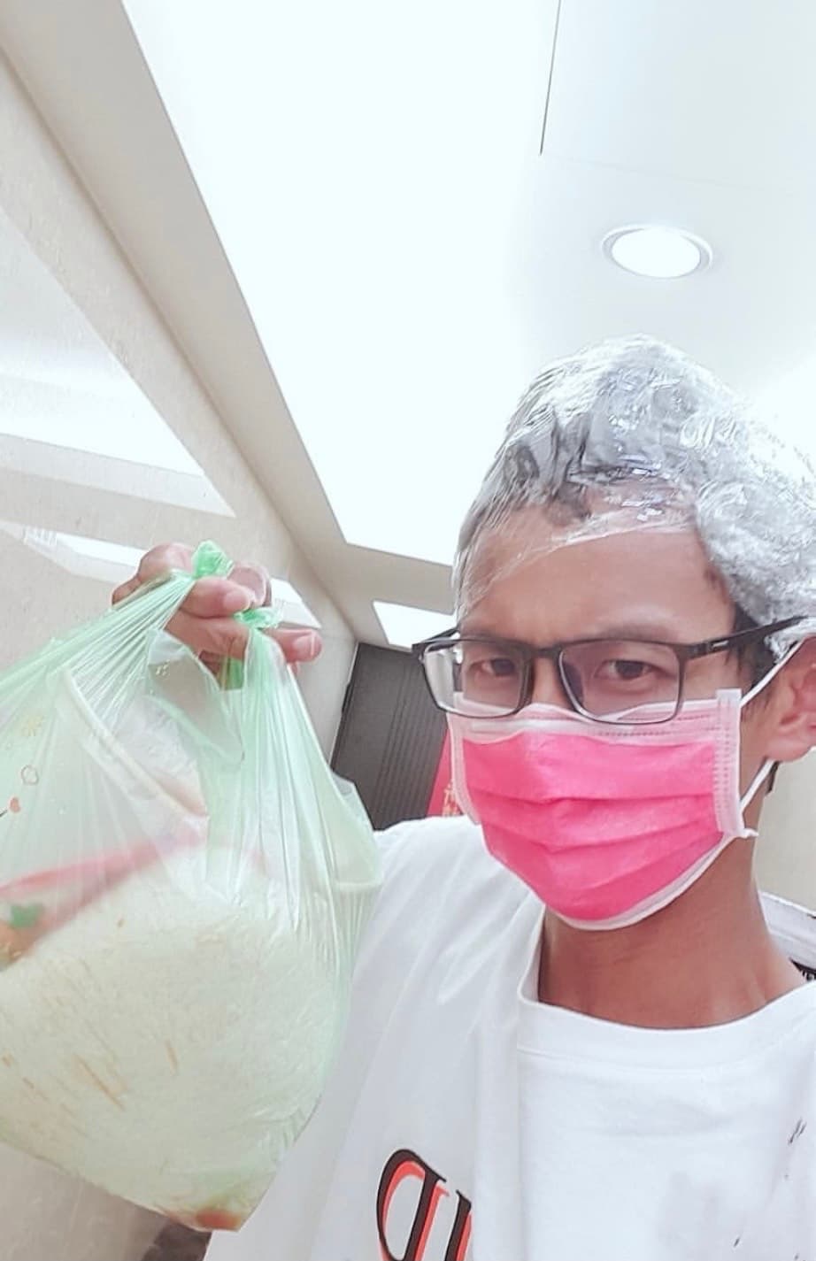 阿翔頂著保鮮膜包頭下樓取餐表情尷尬。(翻攝自阿翔IG)