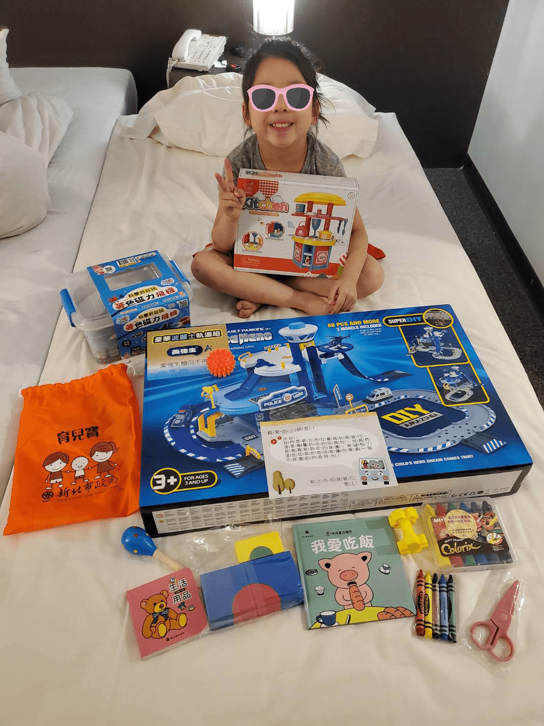 在防疫旅館的小朋友收到新北市玩具銀行送來的玩具,開心在床上開箱分享。(新北市府提供)