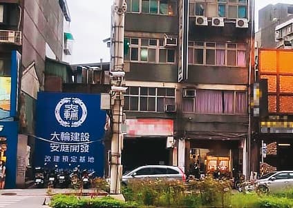 位於北市八德路4段的危老建築，2年前廣告寫著「大輪建設」（藍色看板），大賣預售屋，結果卻是騙局一場，金主「安庭開發」也被騙，成為最大受害者。（讀者提供）