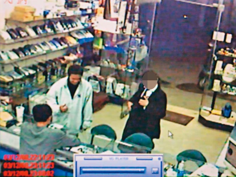 廣德強(白衣者)拿受害女保險員的電腦至通訊行變賣,被趙男識破檢舉,成為破案關鍵。(翻攝畫面)