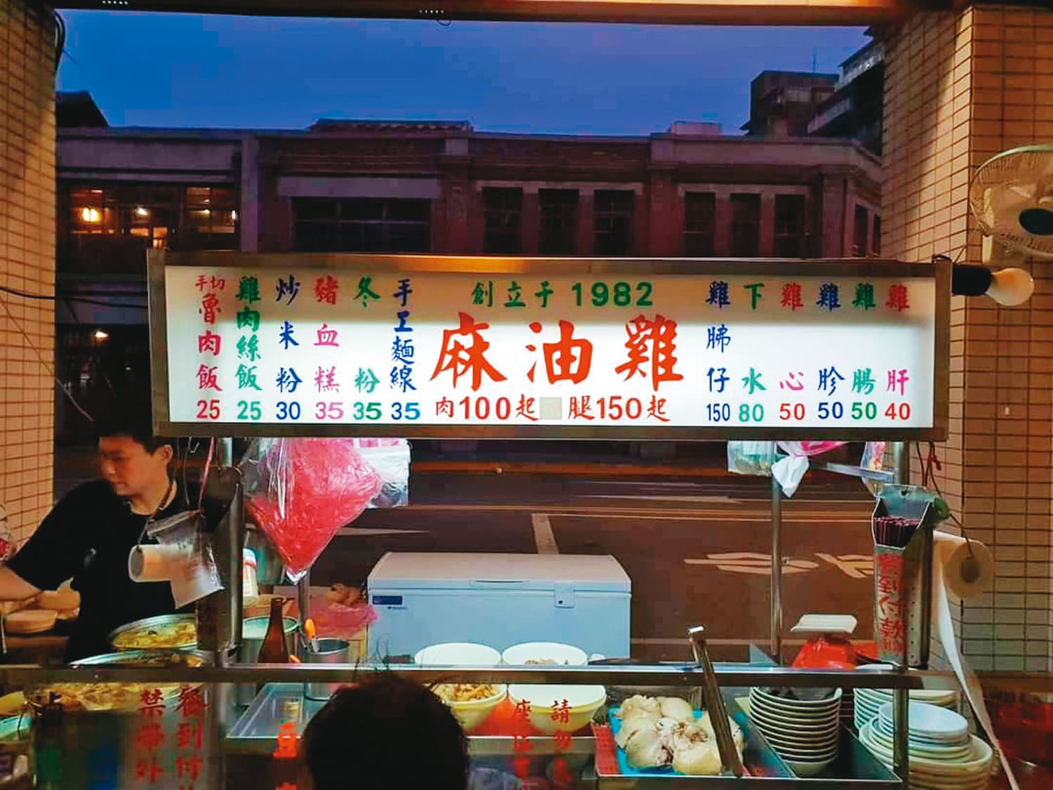 蔴油李原本攤位在剝皮寮對面銀行前,得等下午3點半銀行關門才能做生意。(李佳美提供)