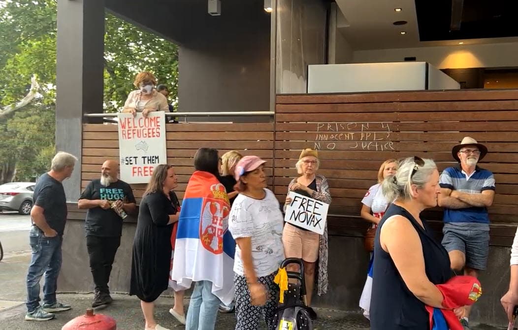反疫苗的球迷在旅館外抗議,要求政府釋放喬科維奇,通通沒戴口罩。(翻攝Cait Kelly推特)