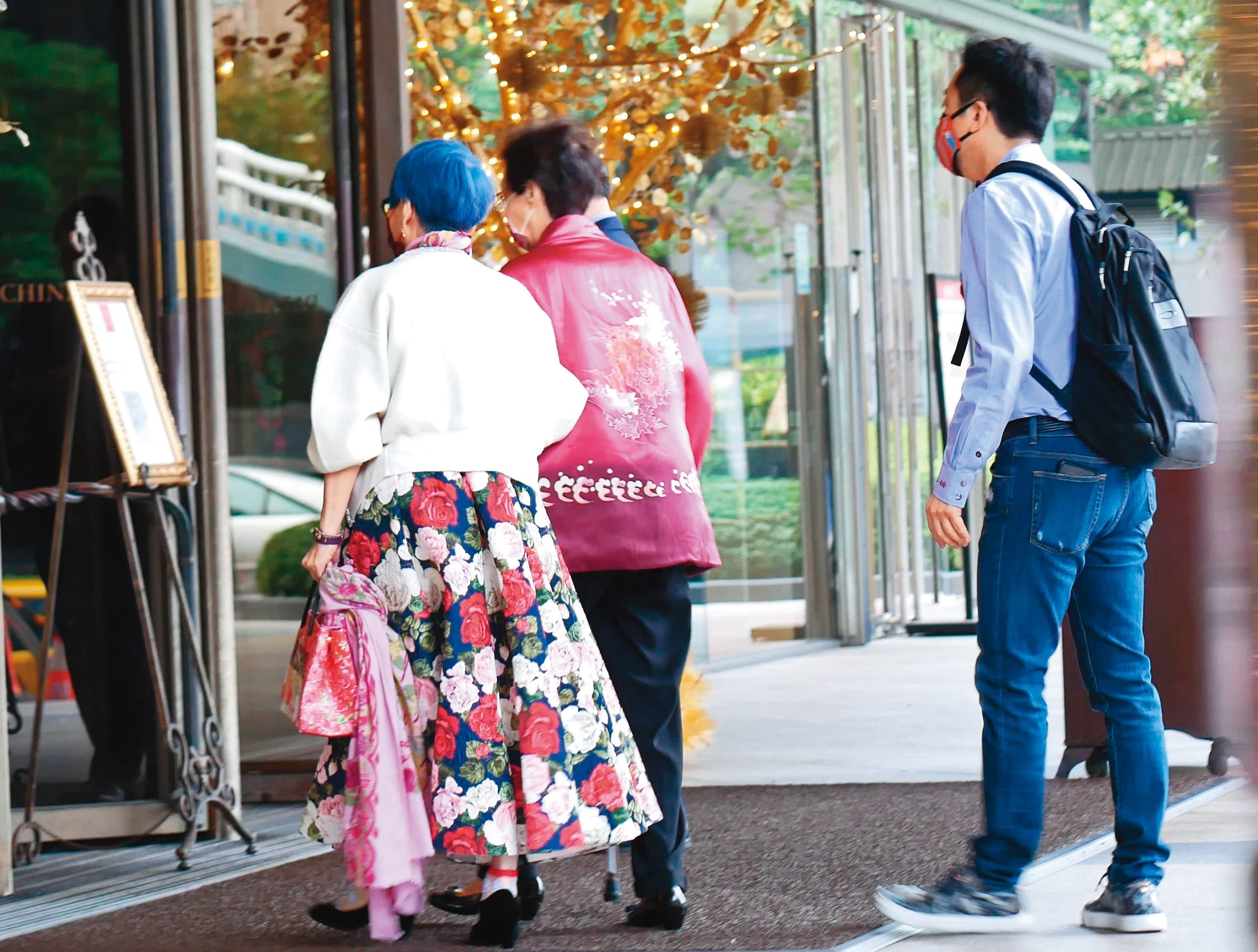 11:57 哈林(右)跟在後面,護送母親(中)和張小燕進入君品酒店頤宮餐廳用餐。