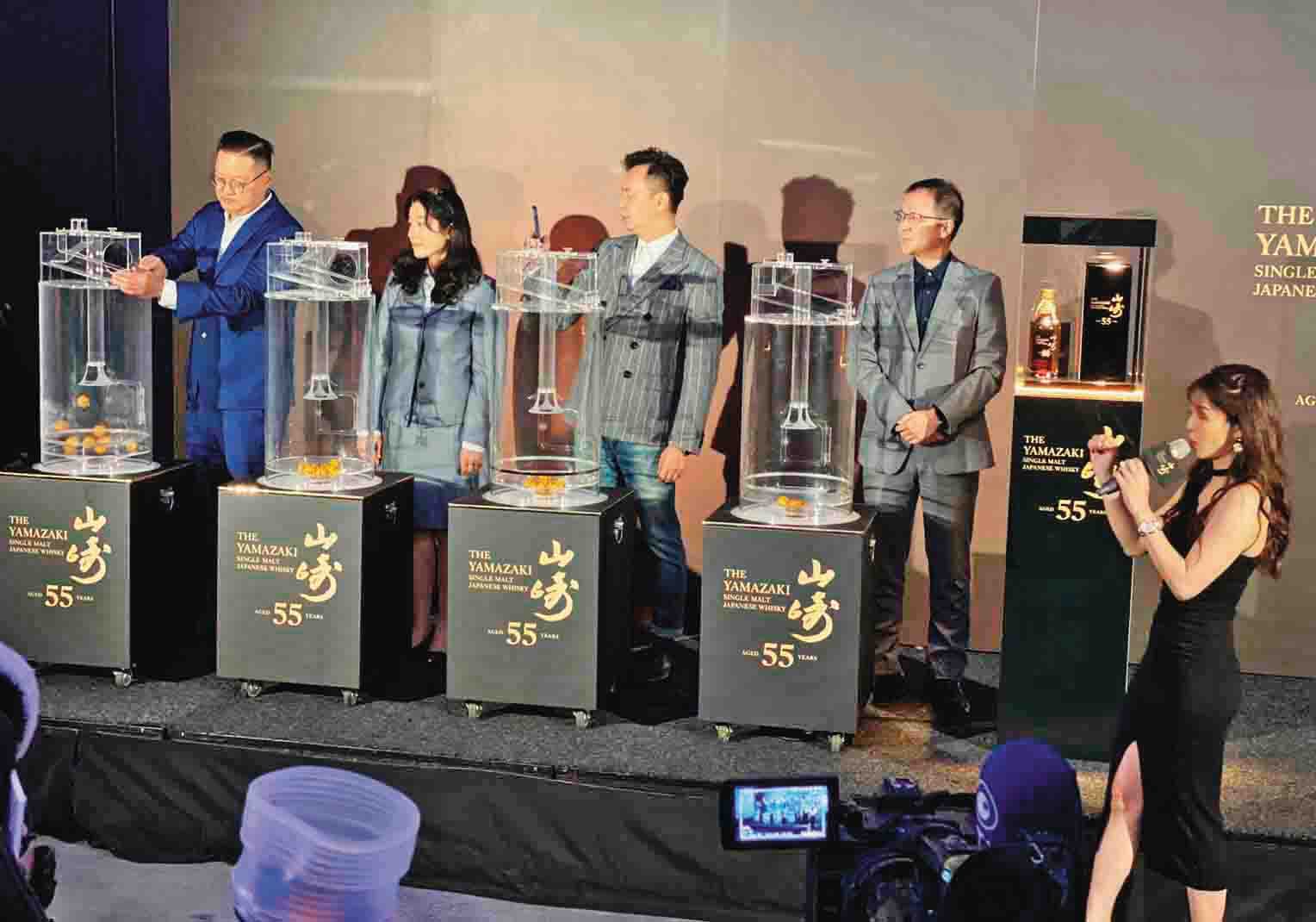 在全場媒體、律師和主持人君君(右1)見證下,台灣三得利4位一級主管:資深業務經理Joe(左起)、財務總監Susan、行銷總監Roger、總經理Alex,依序搖出個位到千位數字。