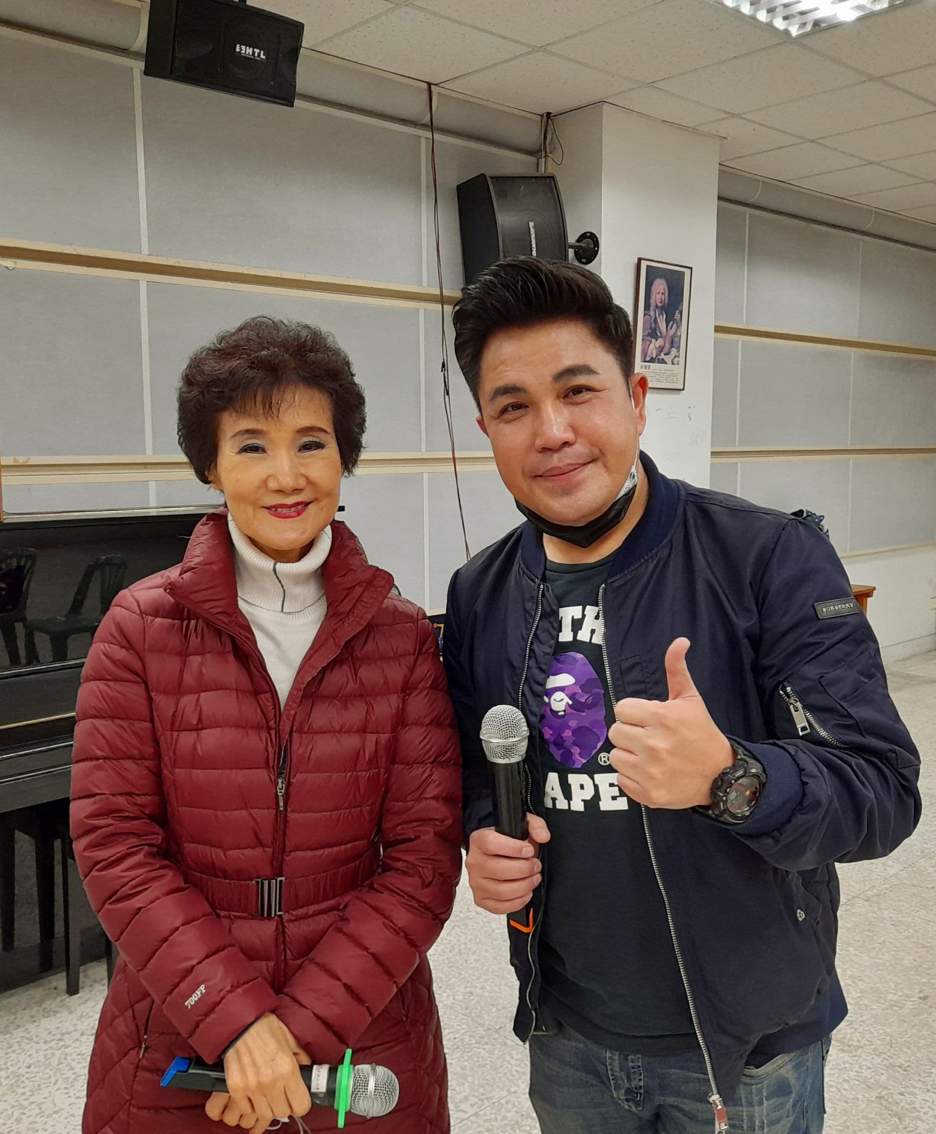 吳靜嫻(左)在松山社大教唱18年,交棒「景行廳男孩」林智賢。(松山社大提供)