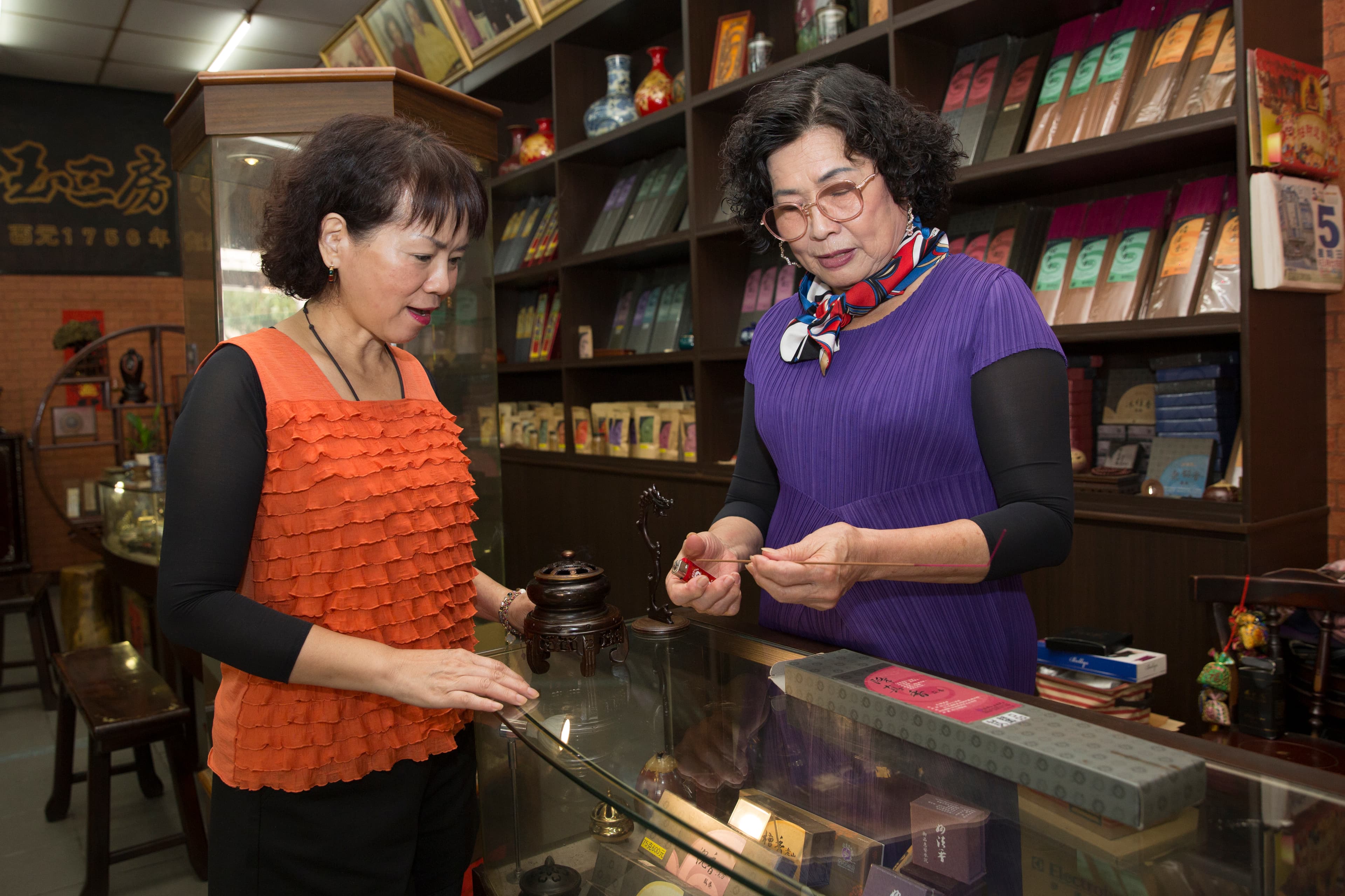 只要客人進店，第7代老闆娘洪寶真（右）一定點香讓客人試聞，詳細解釋何謂中藥養生香。