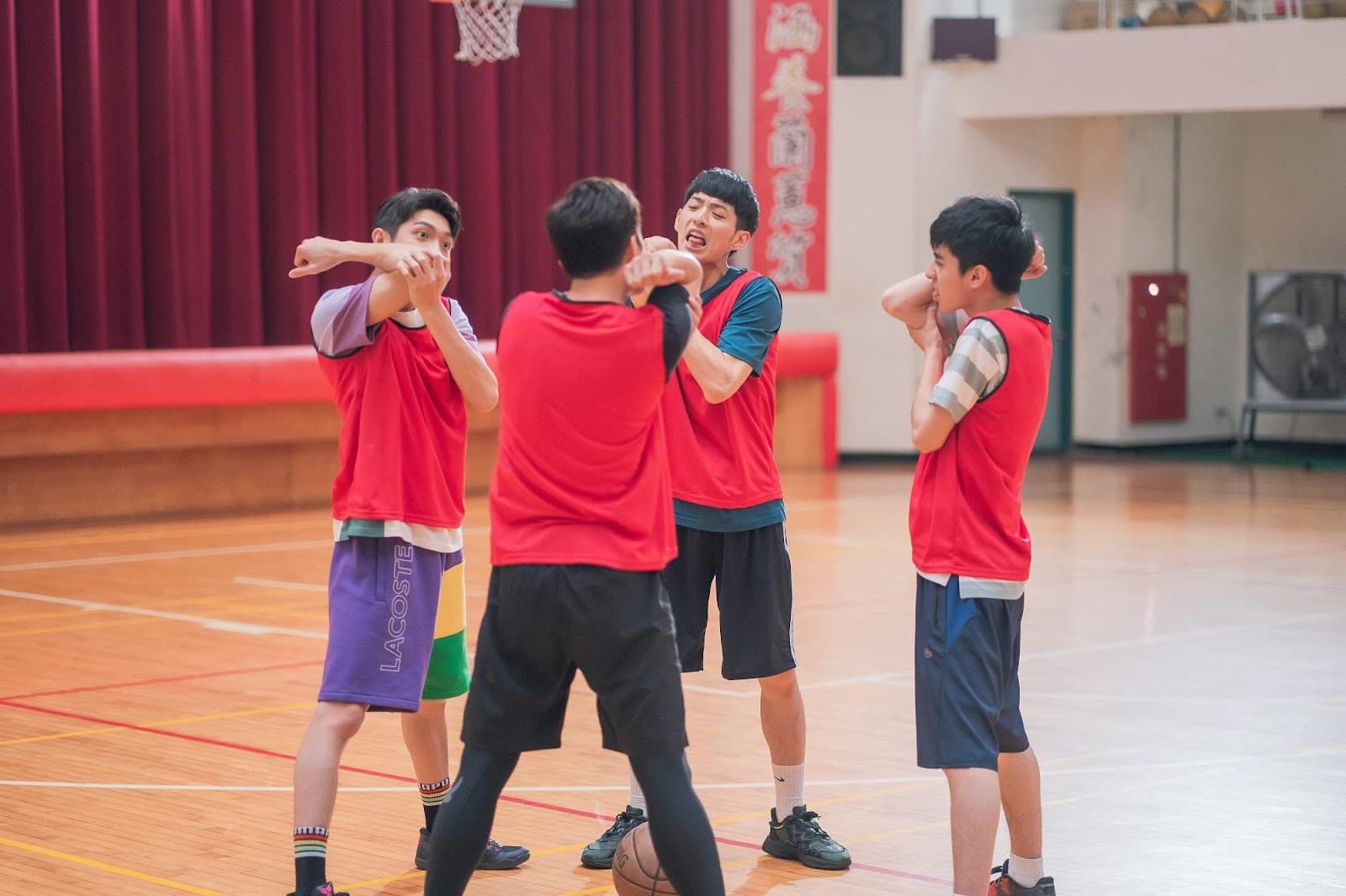 學生演員們想出用舔手肘的方式當成籃球賽熱身運動,宥勝(前中)劇中跟著做,一群人顯得相當無厘頭。(TVBS提供)