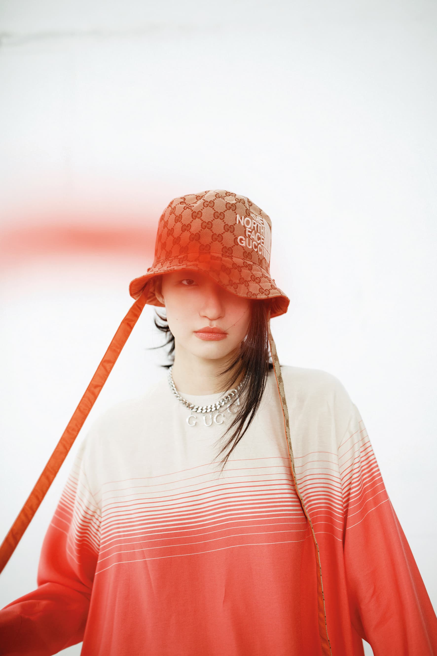 粉白漸層套衫 NT$20,800 by LONGCHAMP/雙面漁夫帽 NT$19,500 by GUCCI x The North Face/銀色手鍊作為項鍊 NT$26,700 by GUCCI