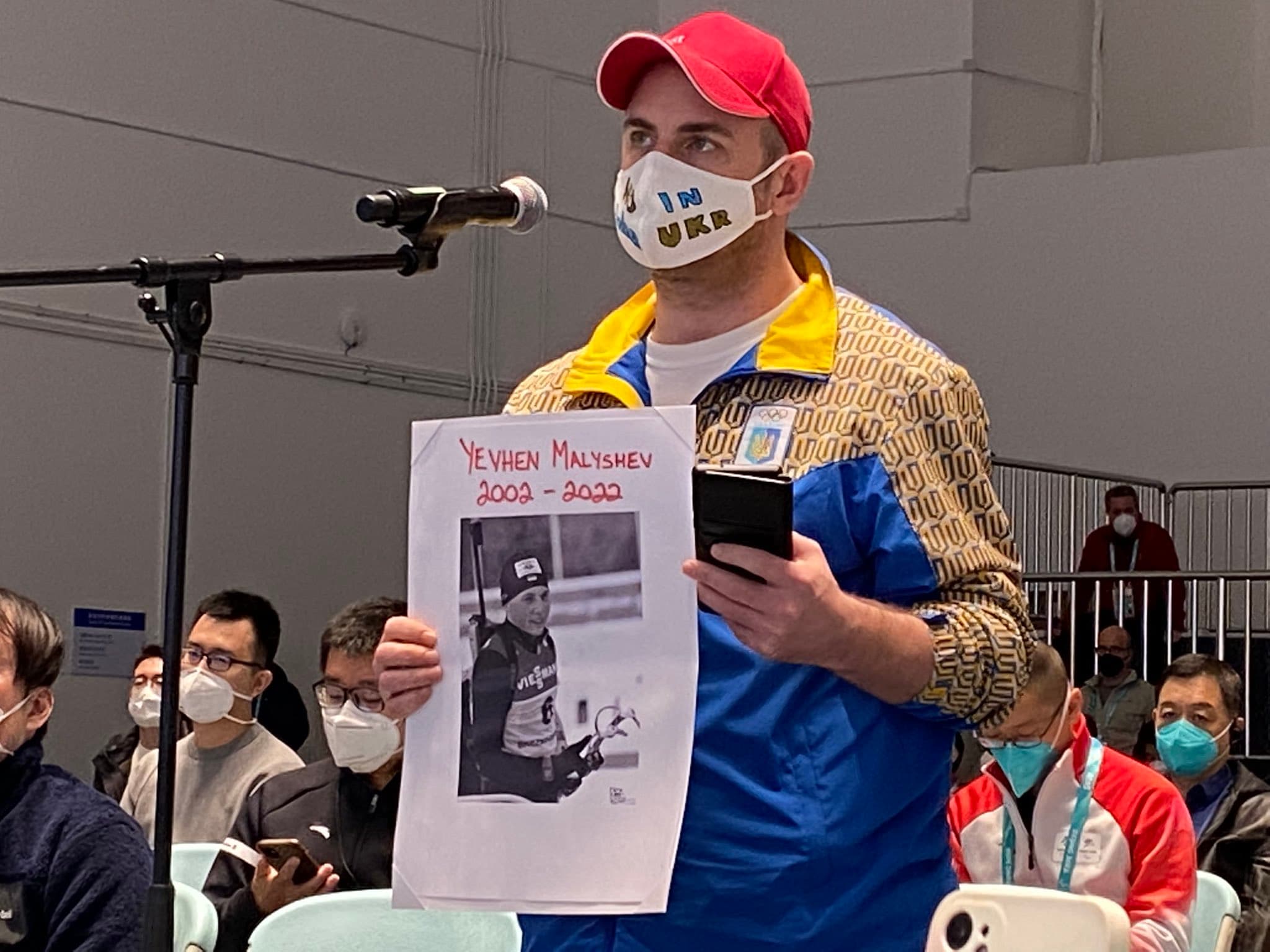 烏克蘭記者拿出在戰爭中罹難的運動員馬利舍夫的照片，質問IPC主席帕森斯有何看法。（翻攝自推特@Devin_Heroux）