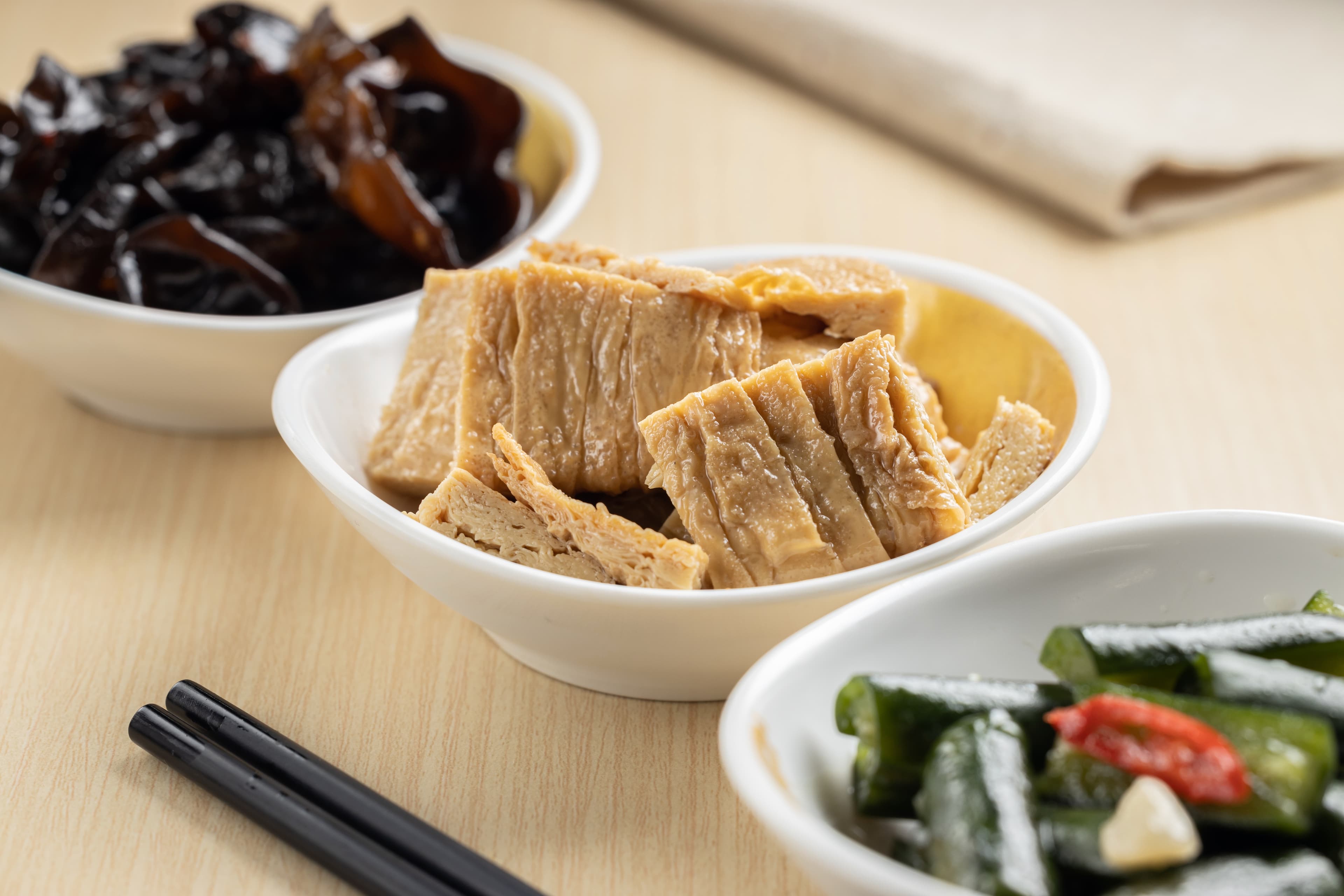「麻油豆包」（中，58元／份）採用「本家生機」的非基改豆包，淋上純黑芝麻油提香；「湯燒川耳」（左）和「涼拌黃瓜」（右），在製作上也很講究。（皆35元／份）