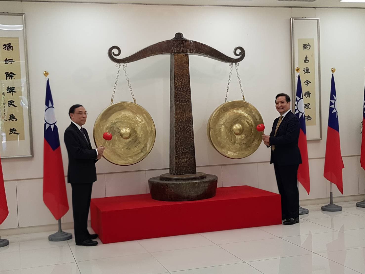 行政院政務委員羅秉成(右)及法務部長蔡清祥(左)主持司法之秤捐贈儀式,2人共同敲響銅秤,代表發出正義之聲。