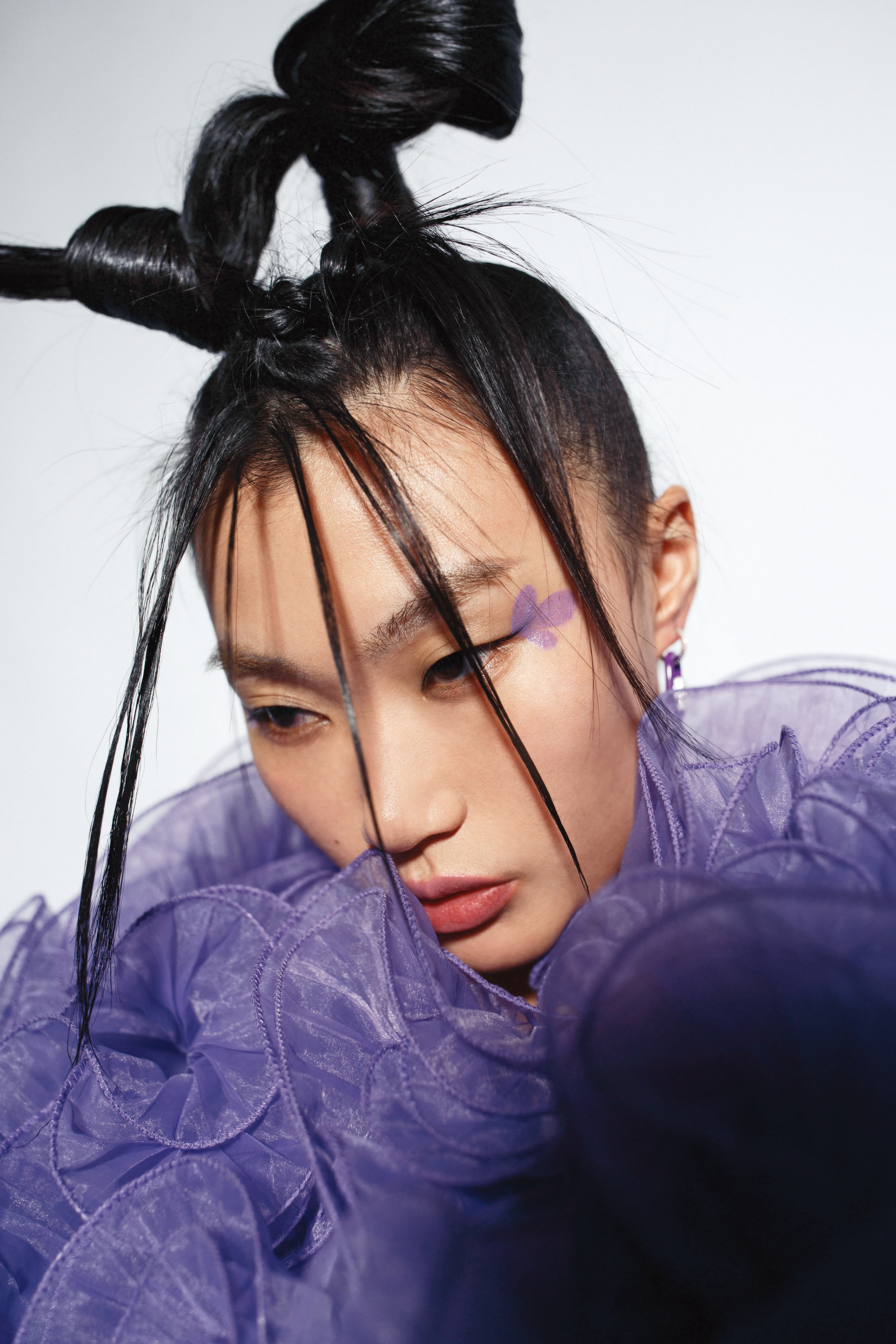 紫色荷葉邊外套NT$9,999 by Iris Apfel X H&M、紫色環扣耳環(單只)NT$4,200 by APM Monaco。