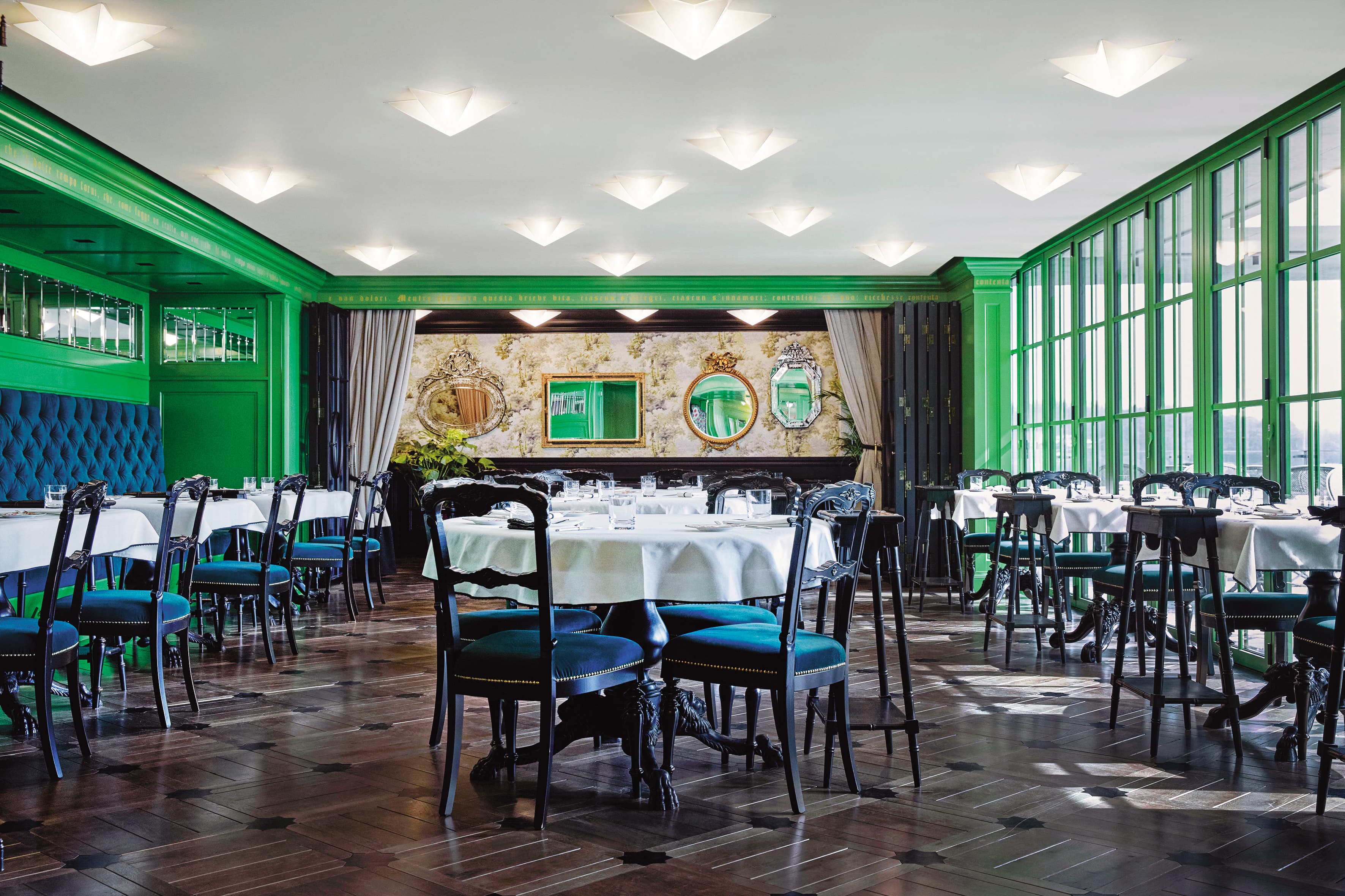 一到Gucci Osteria da Massimo Bottura入口處，客人將會沉浸在充滿活力的綠色牆面中，店內從木製鑲板到露台的格魯吉亞酒吧露台門，皆喚起冬季花園的氛圍。