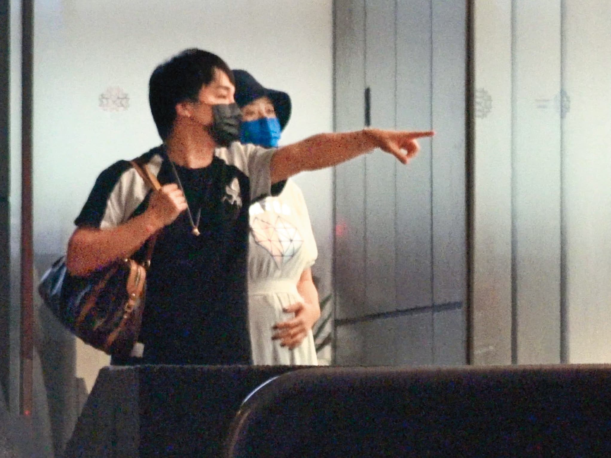 19:32 李亮瑾手撫摸著孕肚,張峰奇負責拿包包,並指向前方。