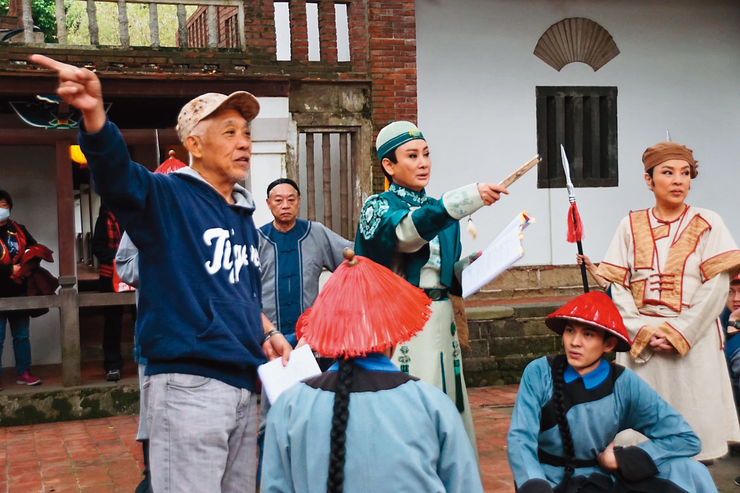製作人陳亞蘭（中）身兼男主角及戲曲導演，在林家花園拍攝現場，與導演葉鴻偉（左）討論演員走位。（欣湉國際提供）