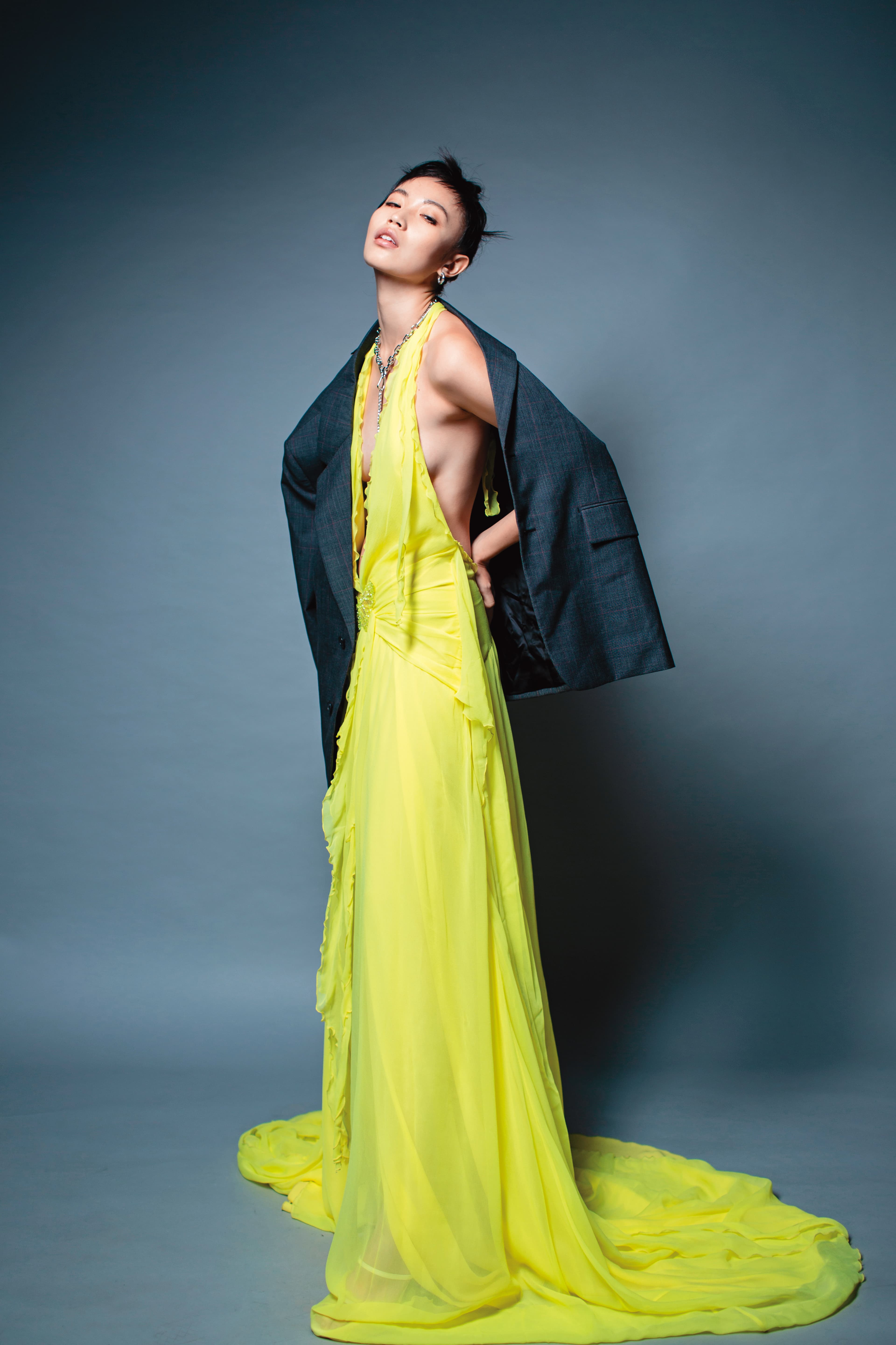 單排扣西裝外套 NT$125,000 by PRADA／黃色雪紡紗長洋裝 NT$97,800 by BLUMARINE／銀色耳環 價格店洽 by LOEWE／黑色愛心金屬項鍊 NT$1,499 by H&M