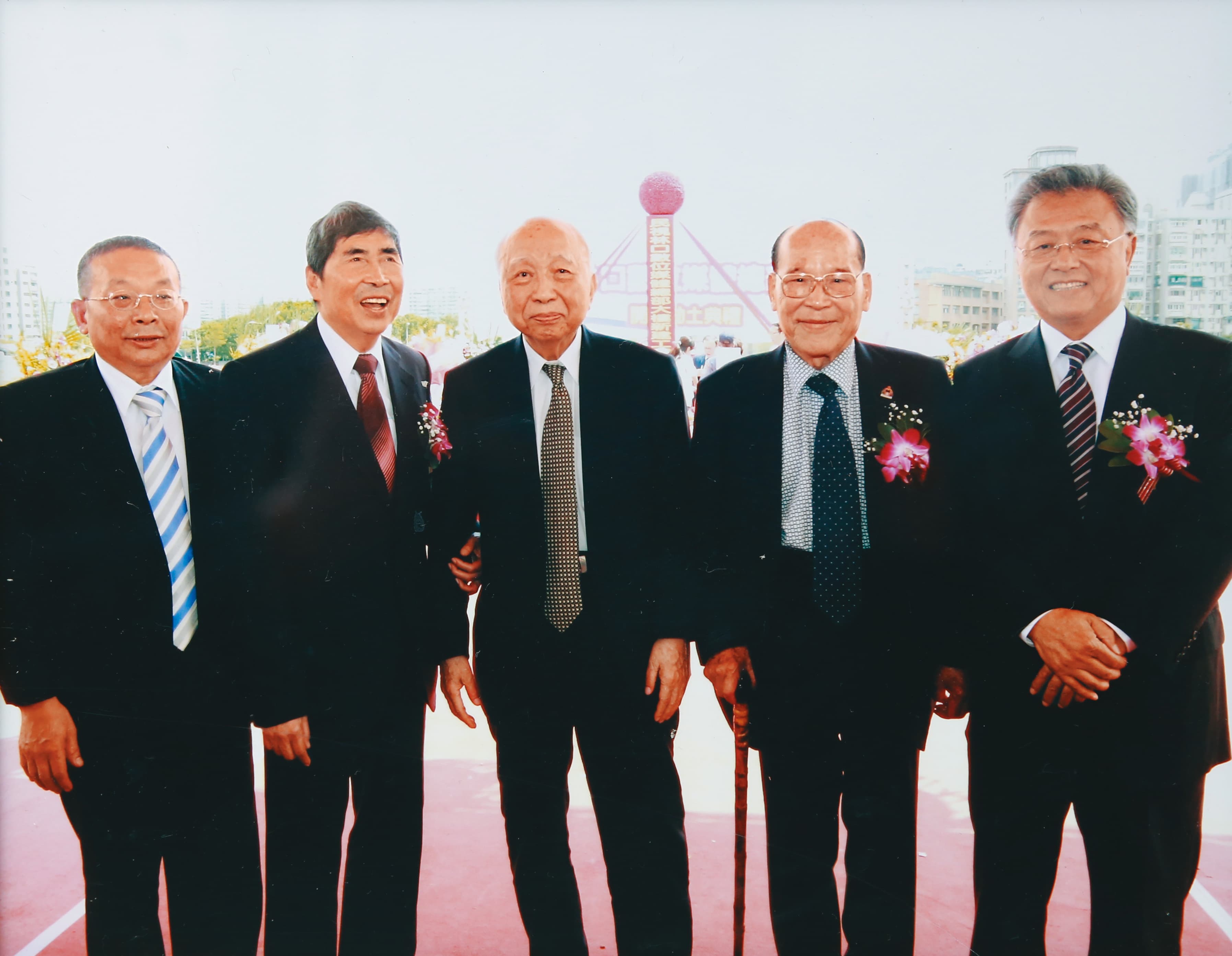 頴川建忠（中）應民視創辦人蔡同榮（左2）之邀投資成為民視大股東，2013年帶老臣陳清福（左1）與民視前總經理陳剛信（右1）、常董田再庭（右2）參加民視林口園區動土典禮。（翻攝畫面）