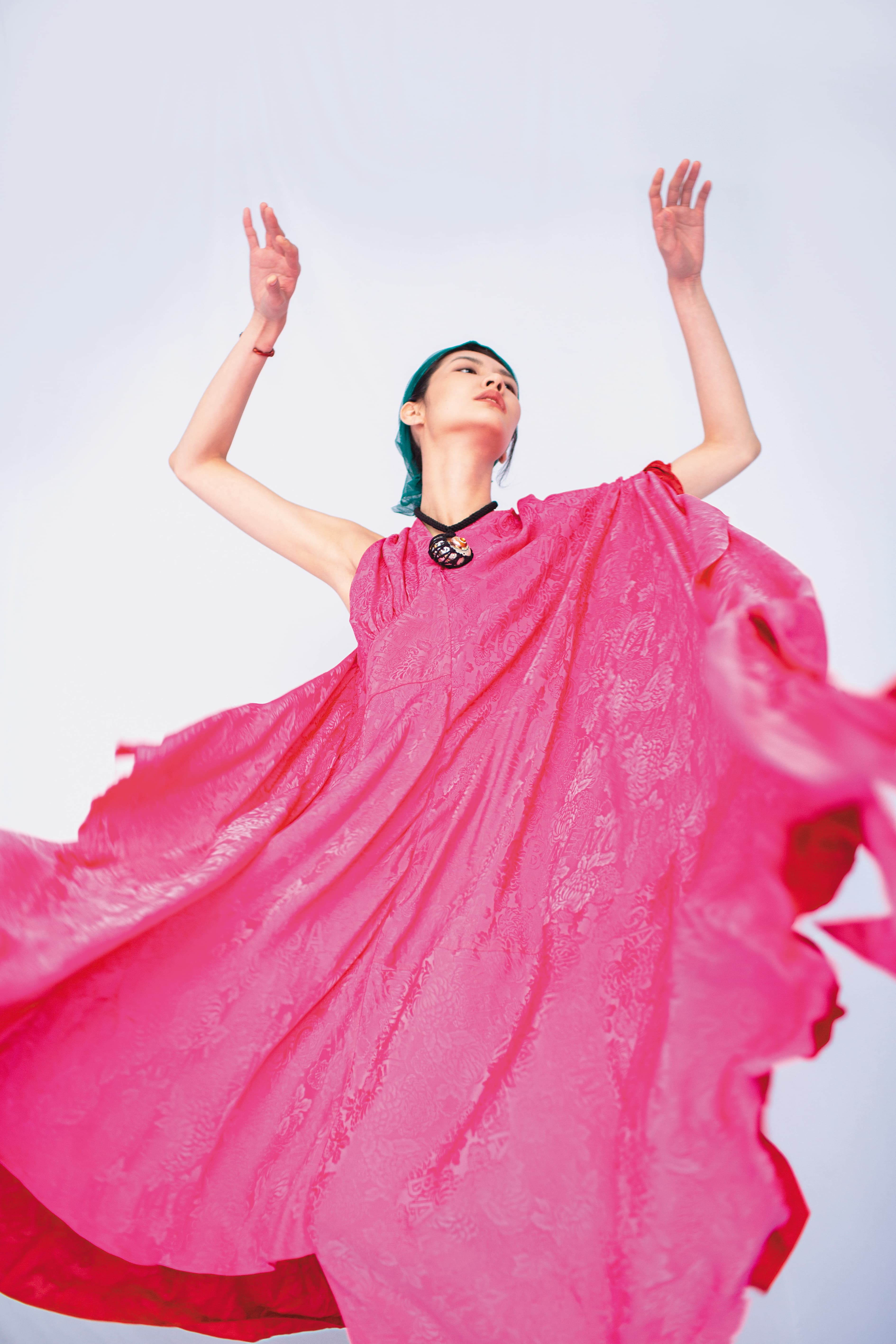 桃紅不對稱造型洋裝NT$141,500 by BALENCIAGA;黑色雙縐絲綢貝殼項鍊NT$25,400 by Chloé;橘紅色納帕紐結造型細手鐲NT$41,000 by LOEWE。