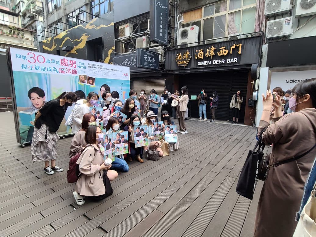 《電影版 櫻桃魔法》忠實粉絲一早6點就抵達電影院現場,熱情與海報合照。(車庫娛樂提供)