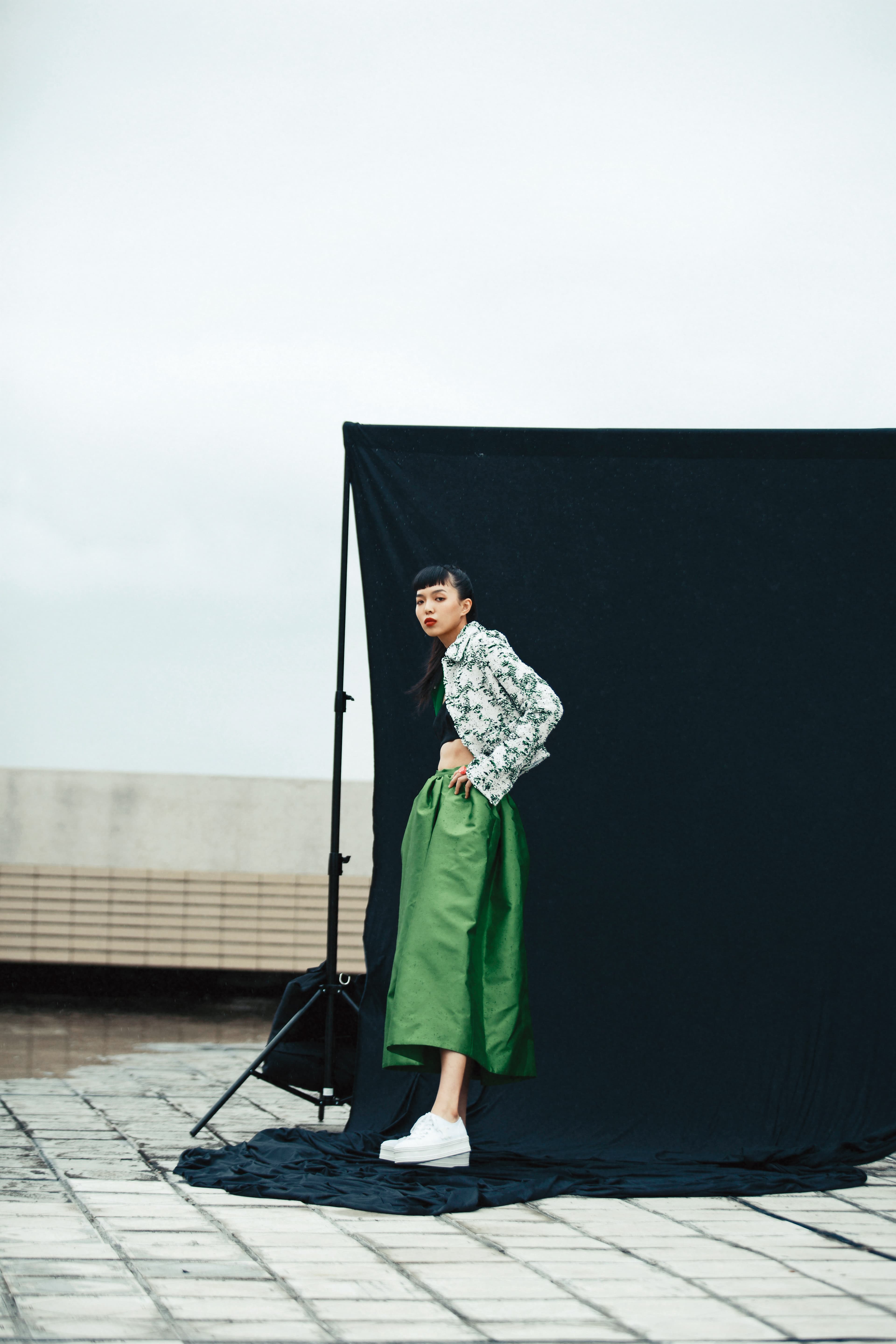 淡紫珍珠呢綠黑緹花紗線短外套NT$82,200 by BOTTEGA VENETA，黑色平口背心 價格未定 by PRADA，綠色蓬裙 價格未定 by PRADA，TRIOMPHE厚底帆布鞋 NT$21,500 by CELINE，Sorbet粉色透明樹脂戒指 NT$18,500 by DIOR。