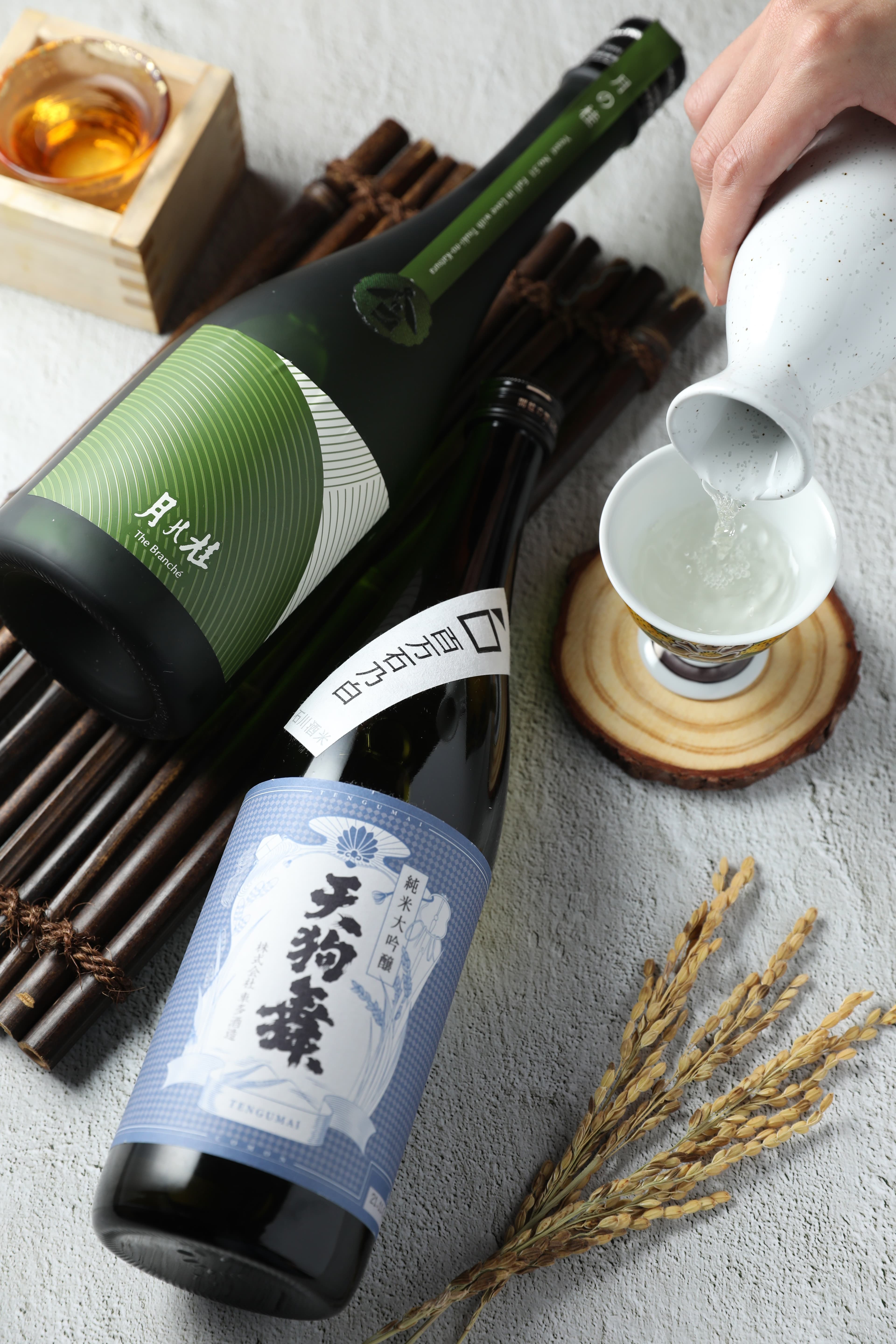 「天狗舞 COMON 純米大吟釀」（前）為「車多酒造」的稀有作品，用酒造好適米「百万石乃白」釀製，礦石氣息清晰。「月之桂The Branche」（後）加入京都當地研發的「京之華」酵母，帶有蘋果香。