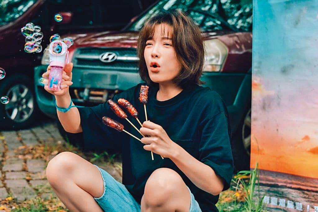蔡淑臻手拿四支烤香腸,這張照片有「細八啦」(十八骰仔)的聲音。(公視提供)