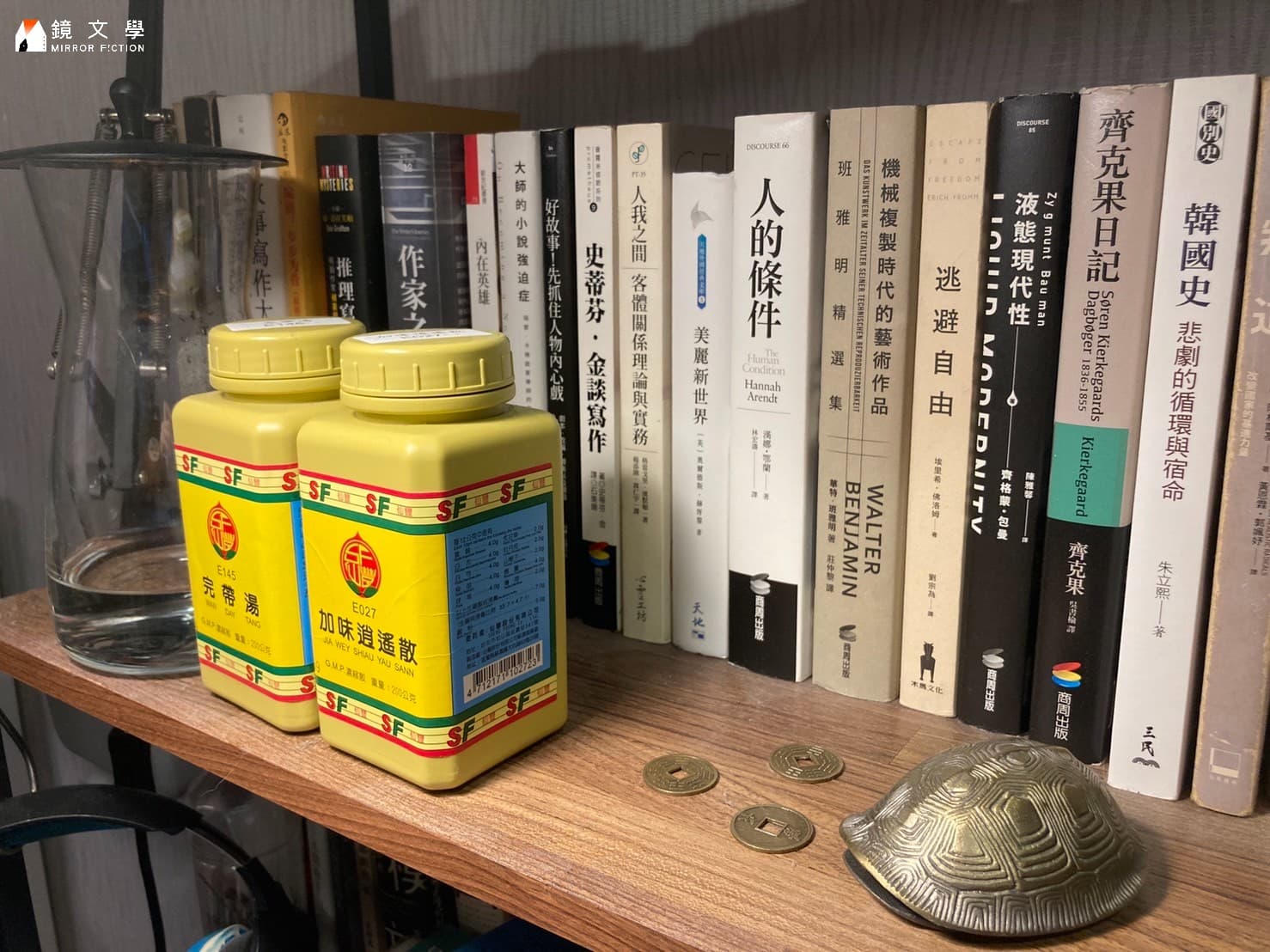 書櫃一隅,不同於其他寫作者,還多了中藥罐跟刻有卦象的錢幣。(孫明立提供)